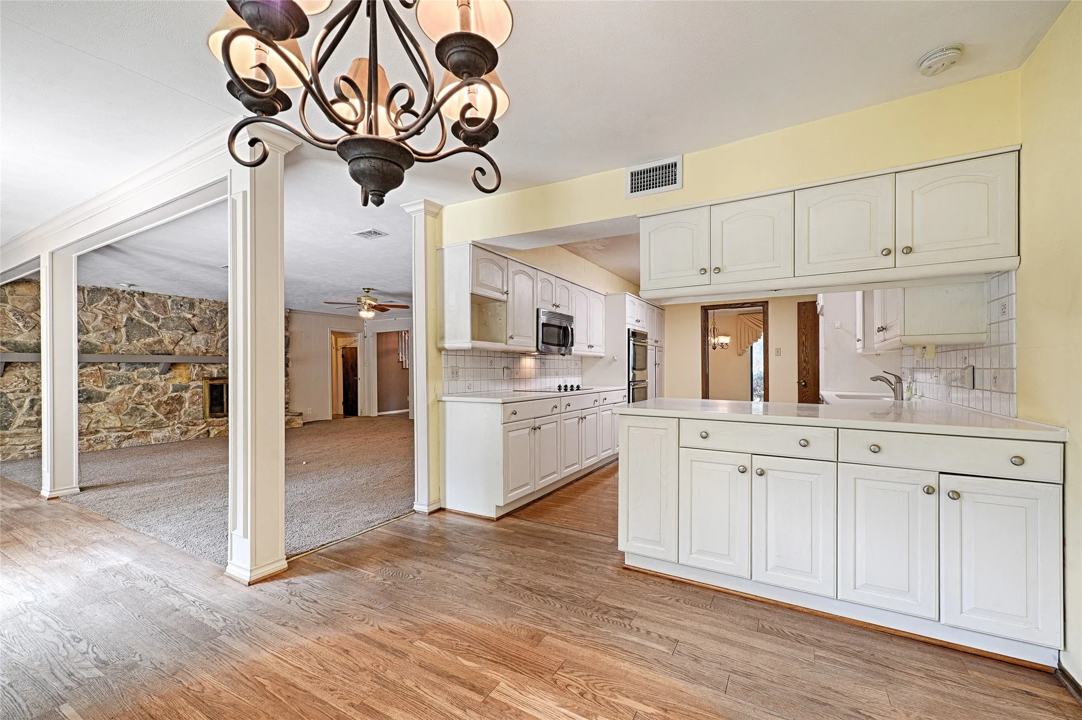 Kitchen with white cabinetry, light-toned countertops, and subway tile backsplash