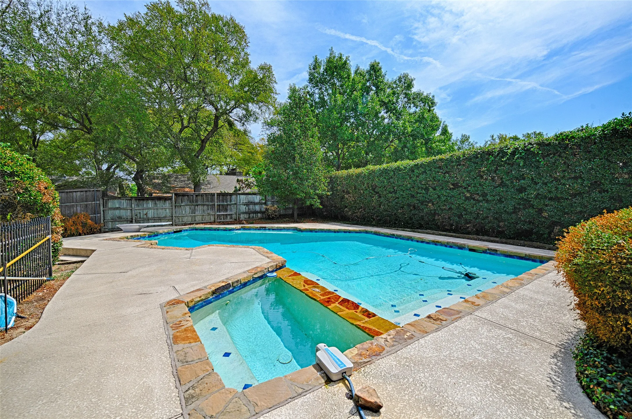 Swimming pool with integrated spa and stone coping