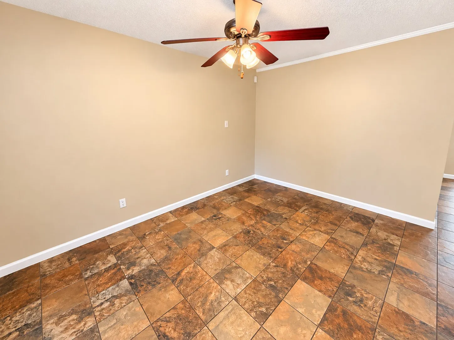 Textured tile flooring, ceiling fan with integrated lighting, neutral wall tones, white trim