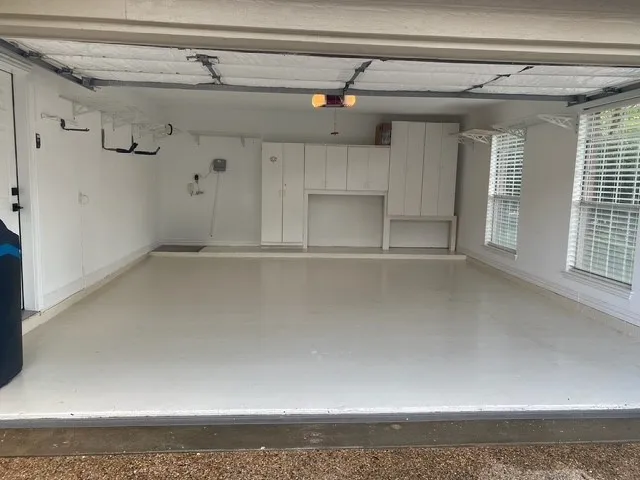 Garage with light-toned flooring, built-in cabinetry, and integrated shelving