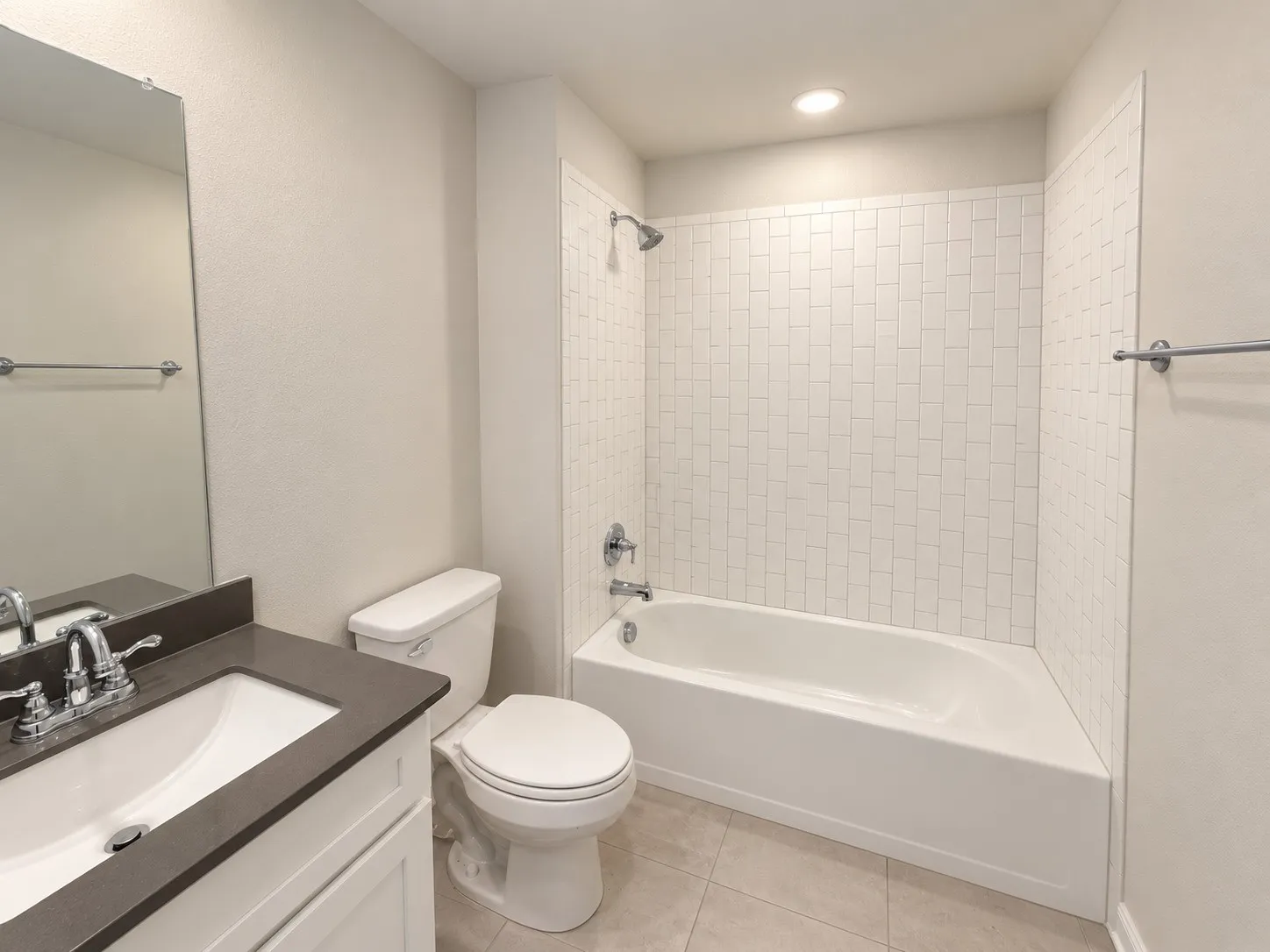Bathroom featuring a white vanity with a dark countertop, an undermount sink, and a chrome faucet
