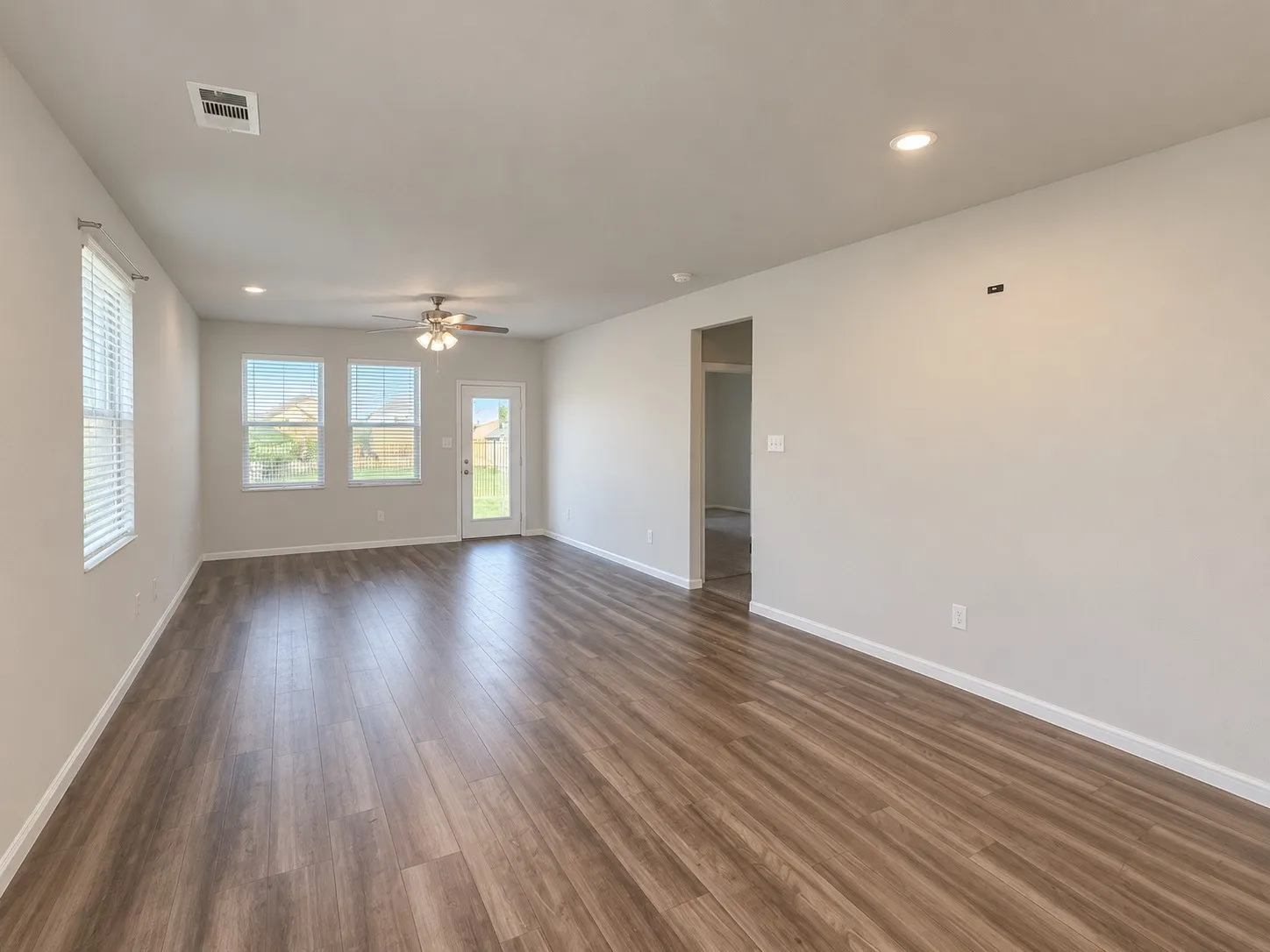 Spacious interior with wood-finish flooring, recessed lighting, and a ceiling fan
