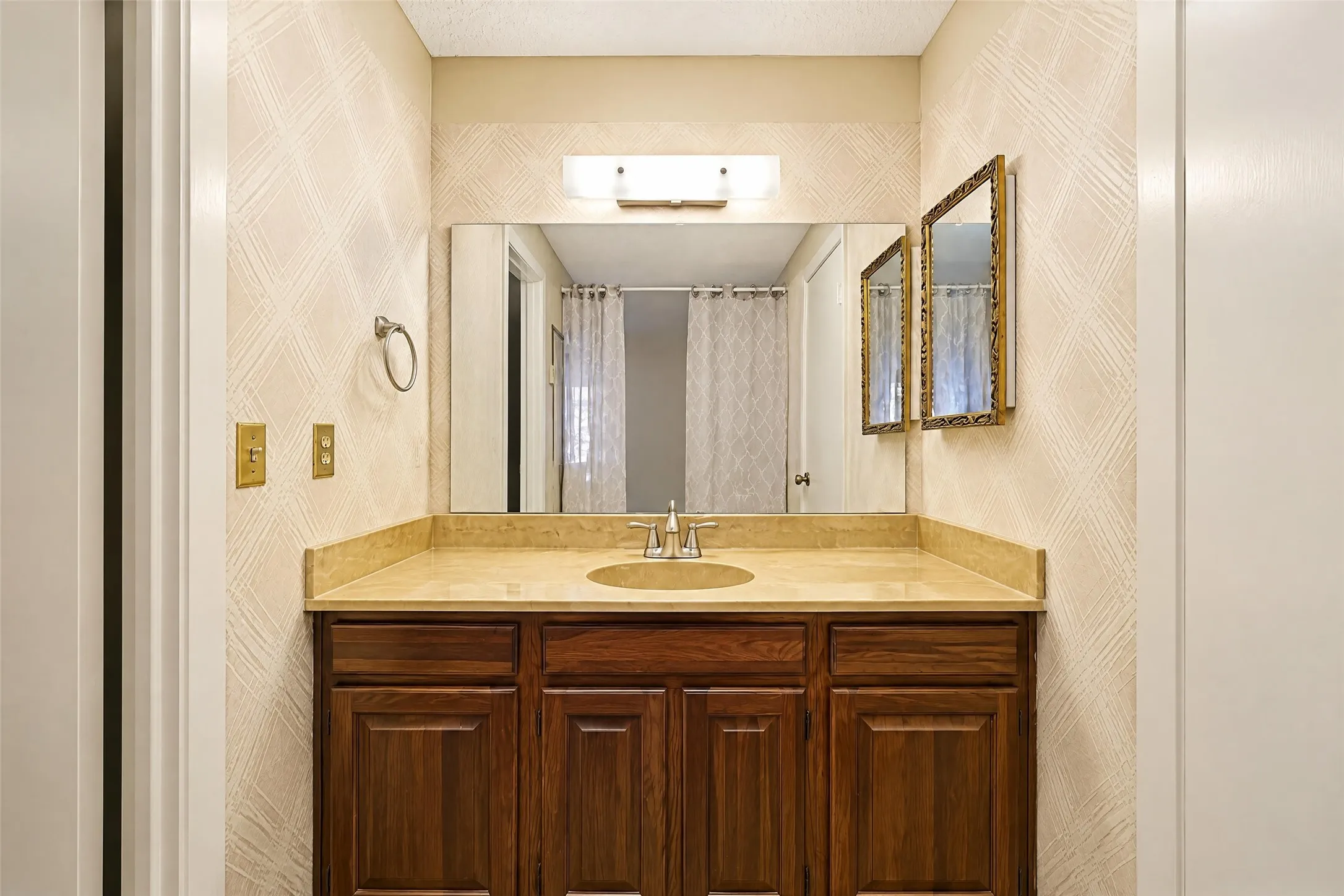 Wood-finish vanity with an integrated sink and light-toned countertop