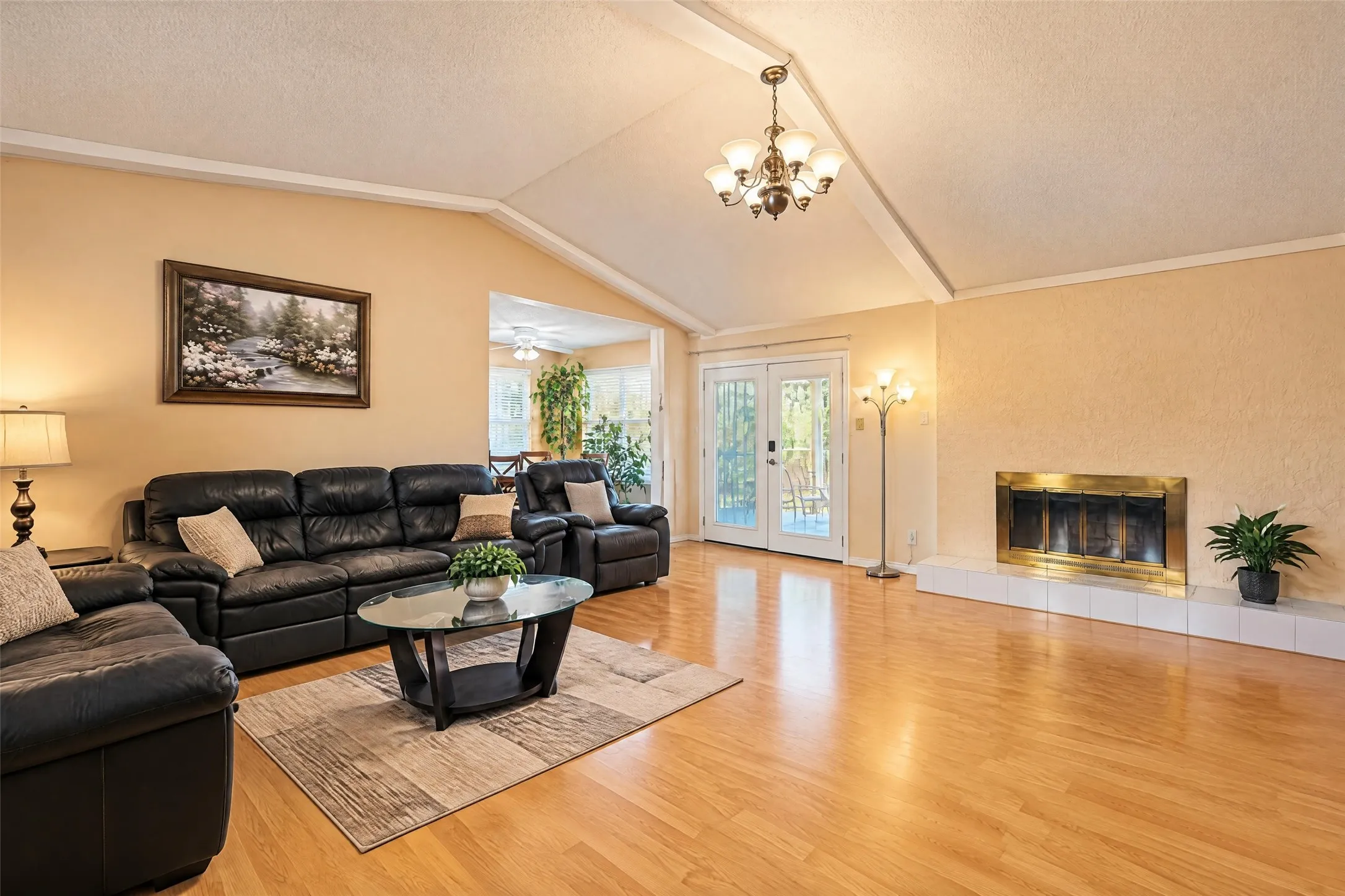 Vaulted ceilings, wood-finish flooring, and a fireplace with a hearth