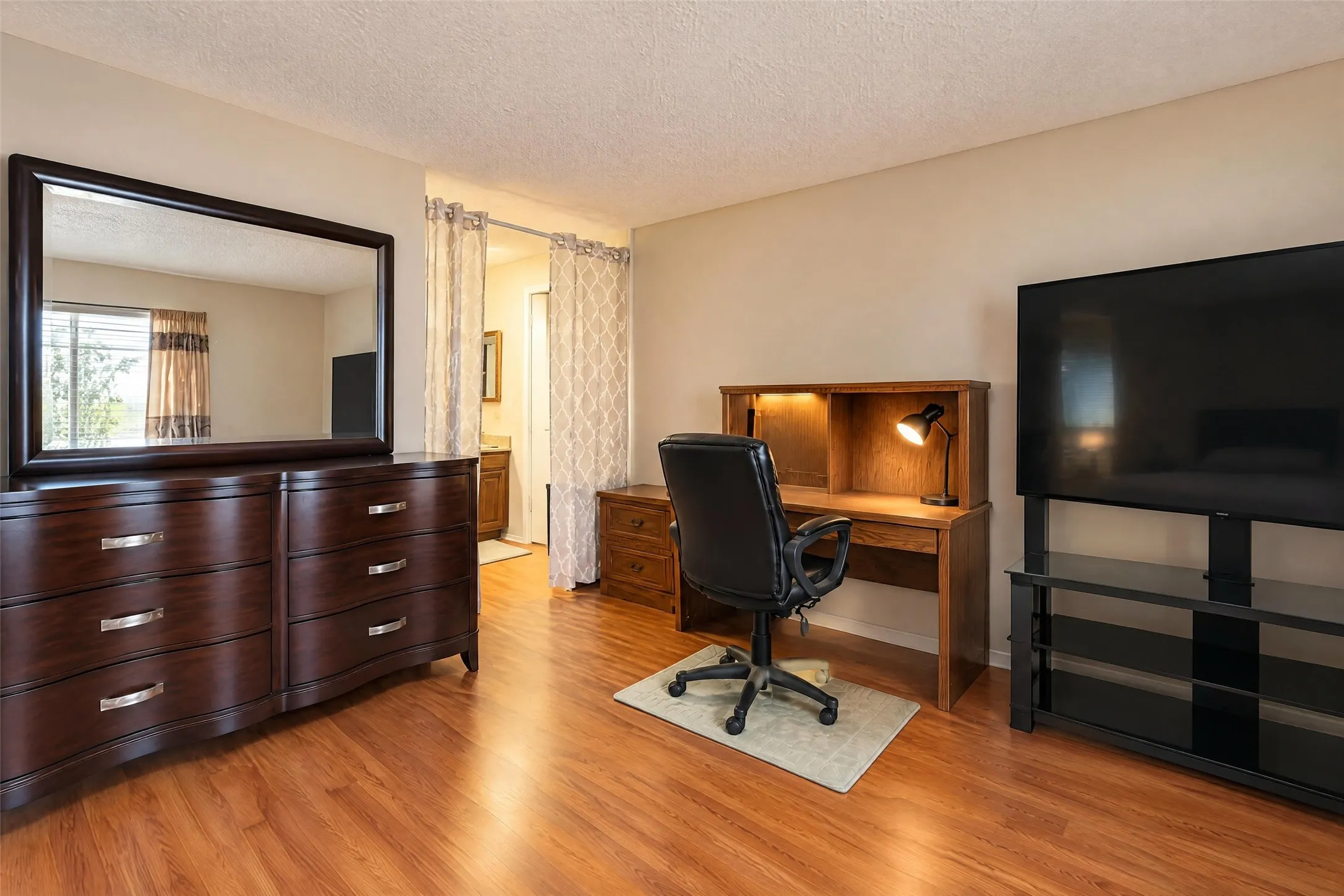 Wood-finish flooring throughout the room with neutral-toned walls