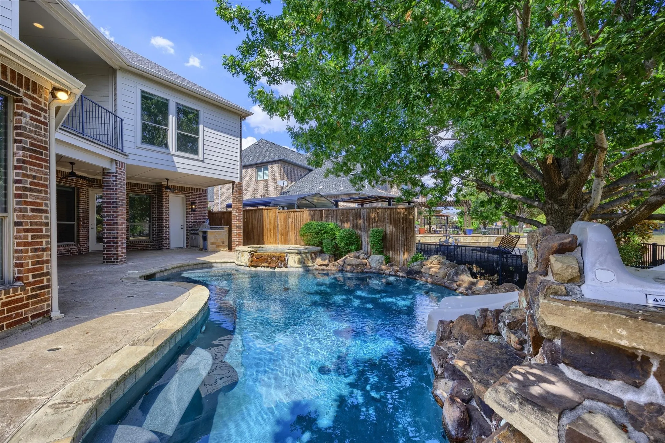 Sparkling pool with slide and view of the greenbelt! Mature trees add privacy.