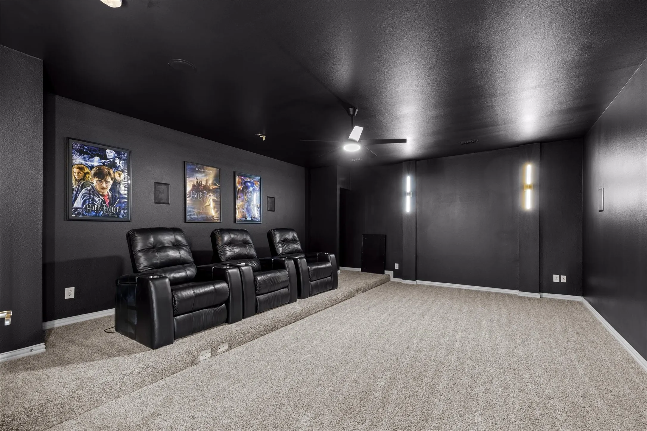 The media room is equipped with theater chairs and movie posters!