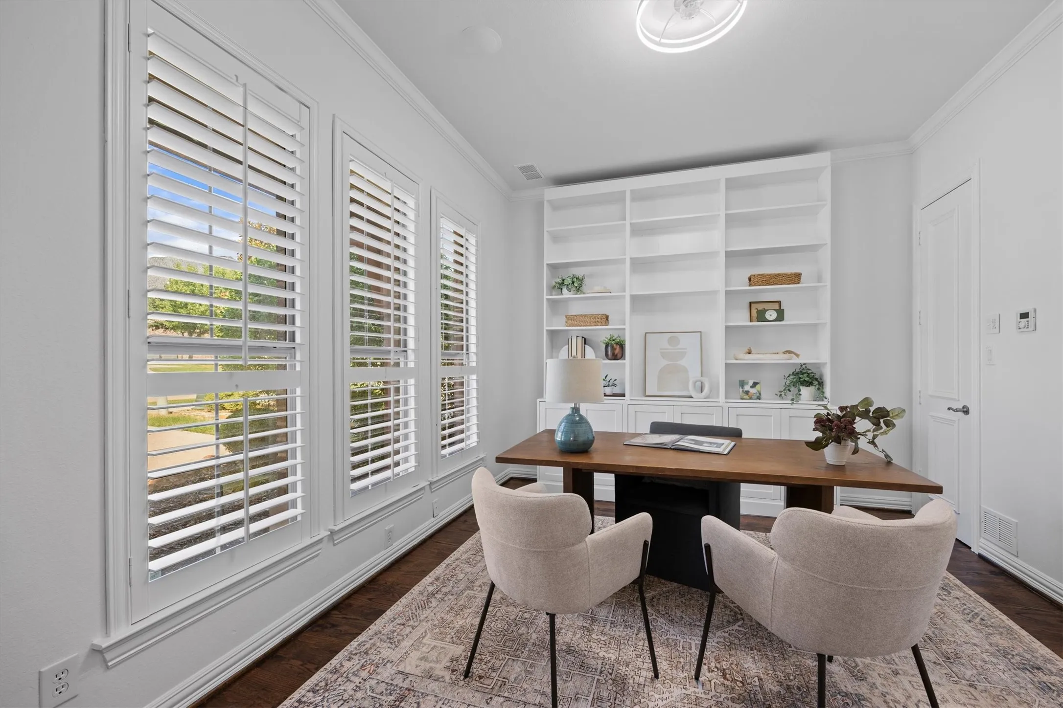 Built in shelving and plantation shutters adorn the office.