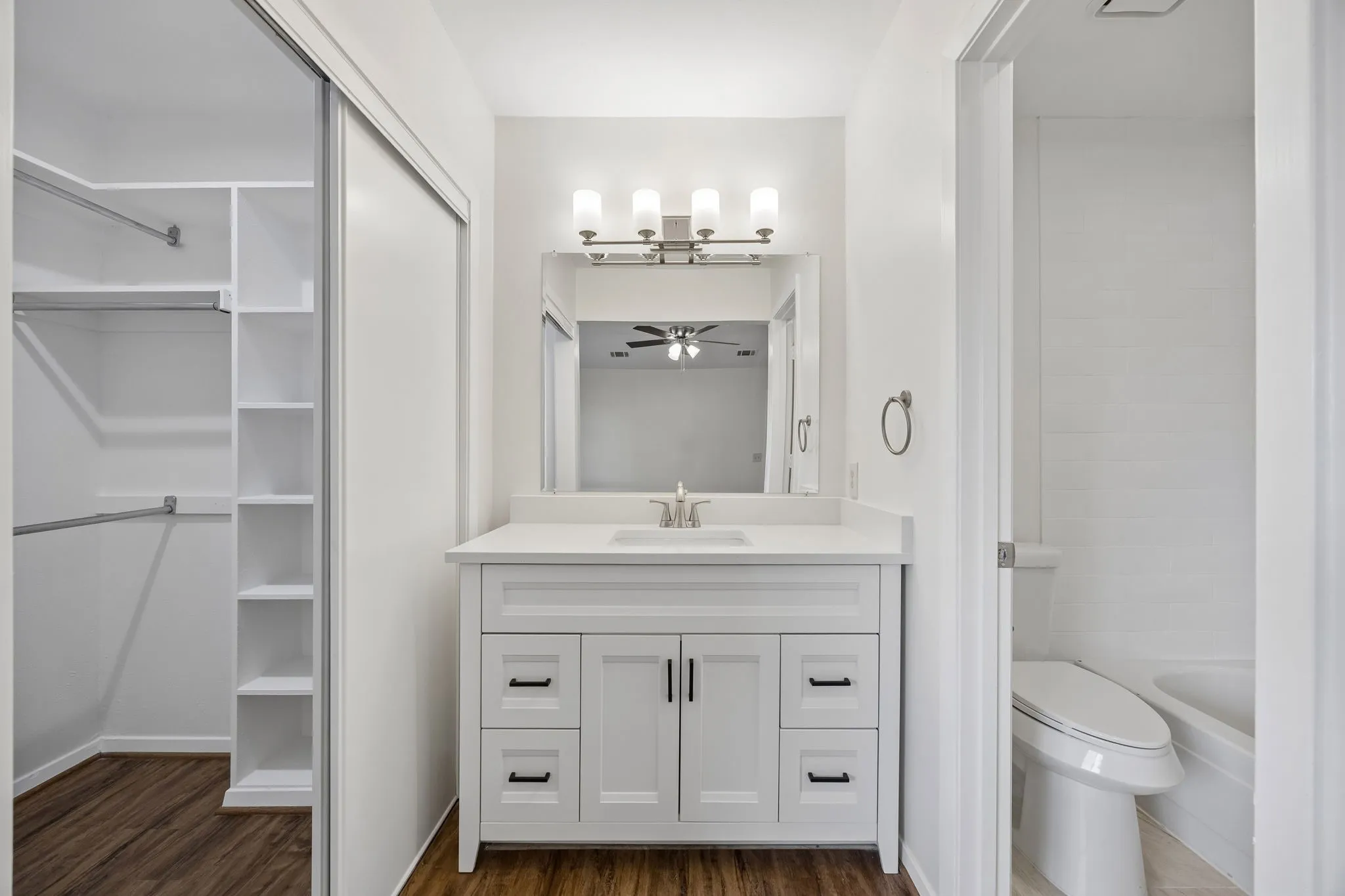 White vanity with a single basin, brushed nickel faucet, and integrated countertop