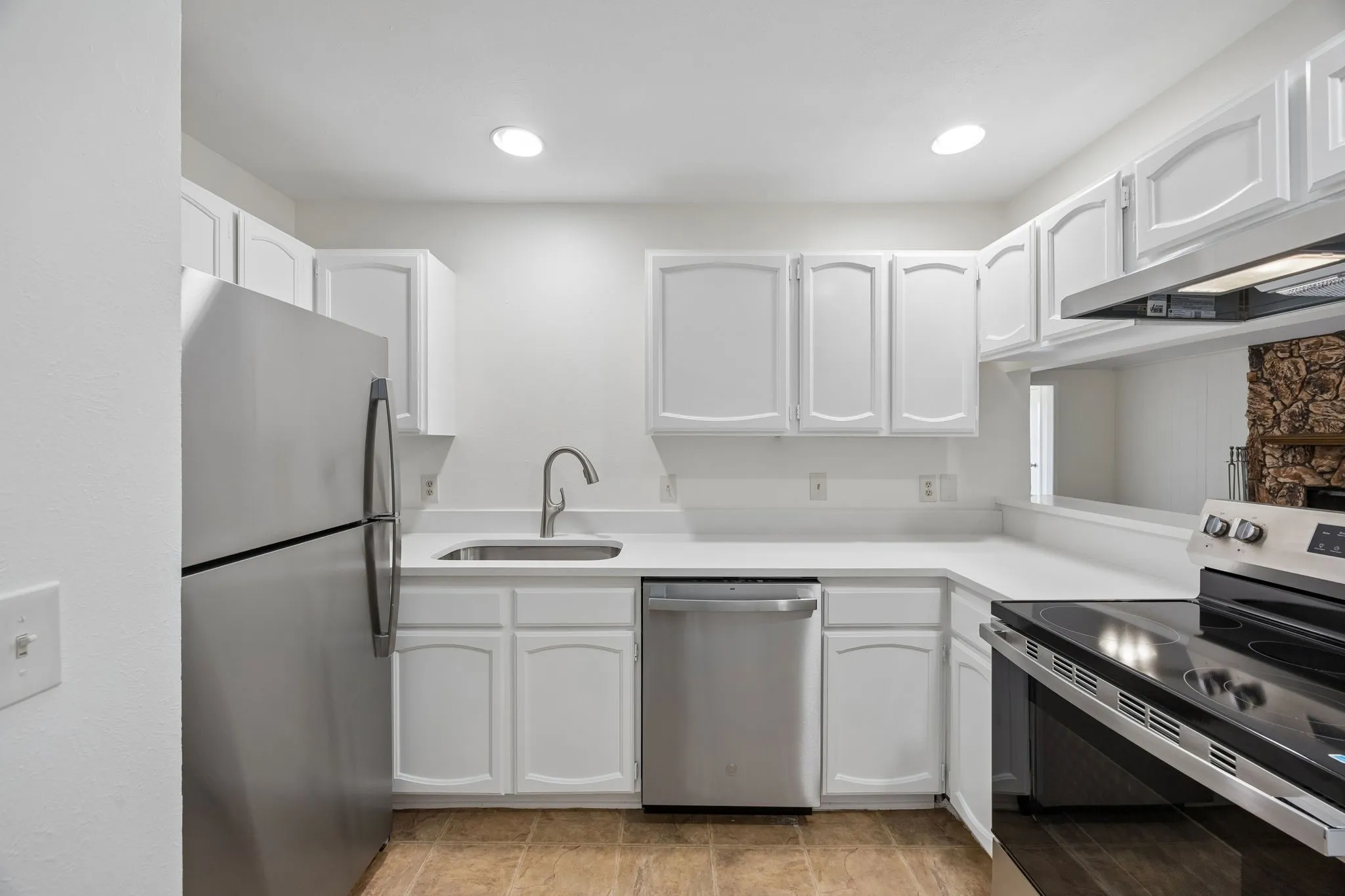 Bright kitchen featuring white cabinetry, stainless steel appliances, white countertops, and recessed lighting