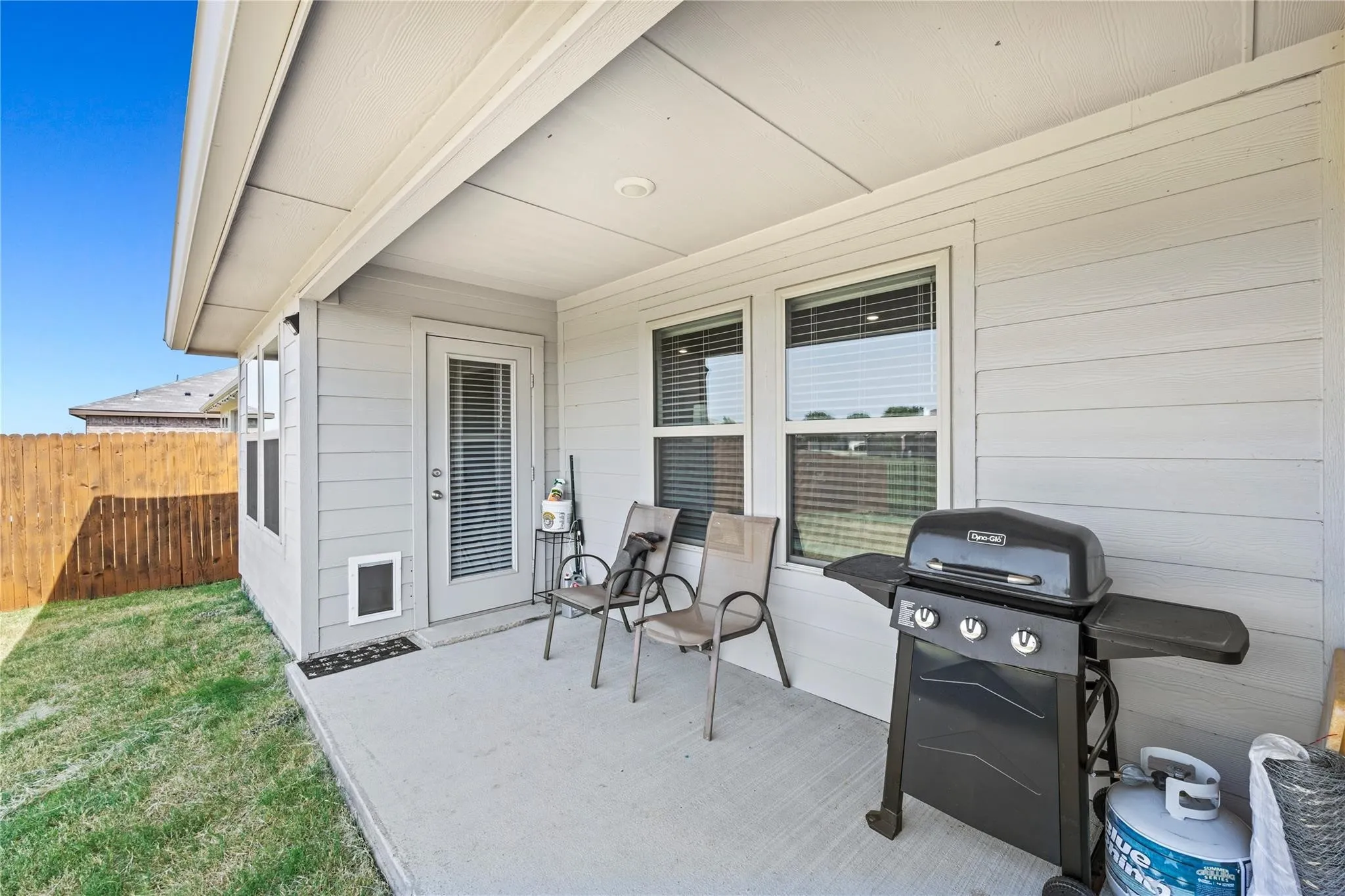 Covered concrete patio with recessed lighting, white horizontal siding, and a fenced yard