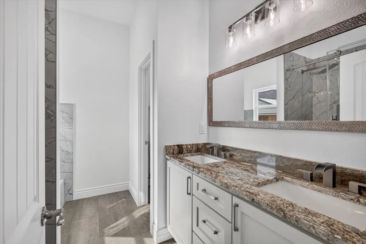 Double vanity with granite countertop, undermount sinks, and contemporary faucets