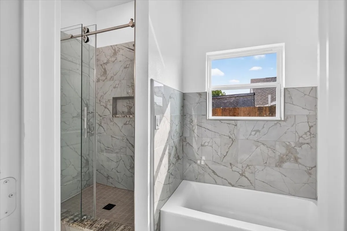 Shower with sliding glass doors, a built-in tile niche, and a tiled shower floor