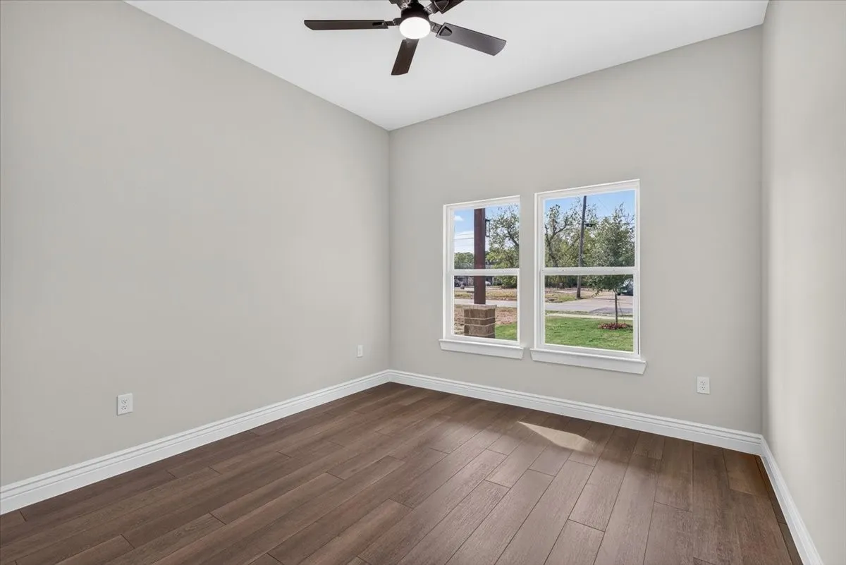 Wood-finish flooring, dual windows, vaulted ceiling, and a ceiling fan