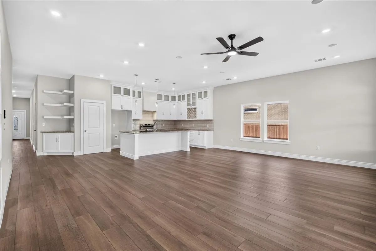 Open-concept living area featuring wood-finish flooring, recessed lighting, and a ceiling fan