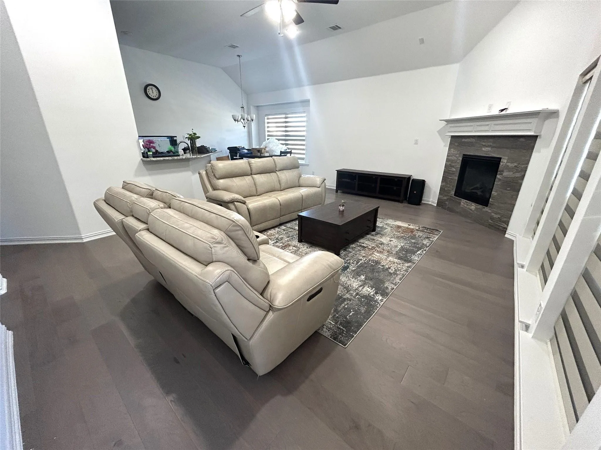 Vaulted ceilings, wood-finish flooring, stone-faced fireplace with mantel, and an open-concept layout