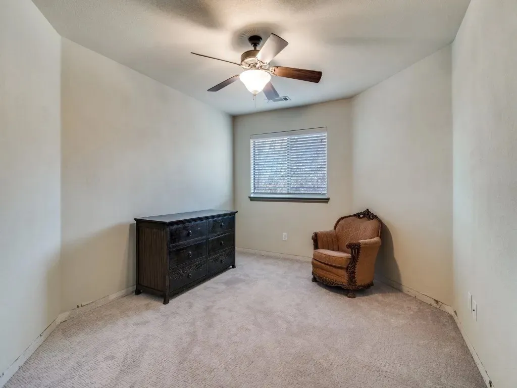 Recessed window with blinds, ceiling fan with integrated lighting, and carpeted flooring