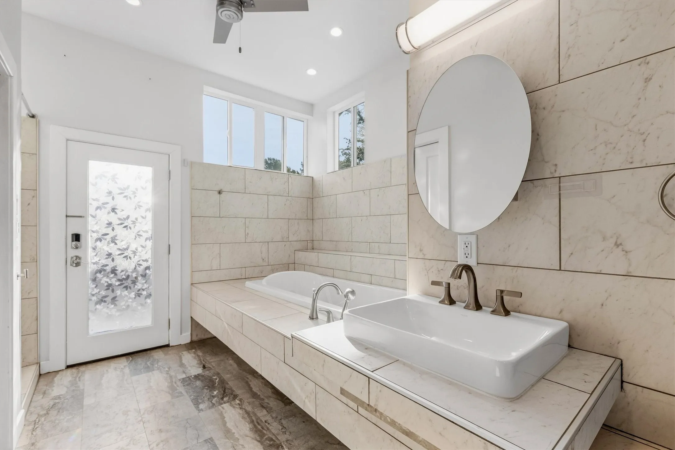 Spacious bathroom featuring a vessel sink, an integrated soaking tub, recessed lighting, and a ceiling fan