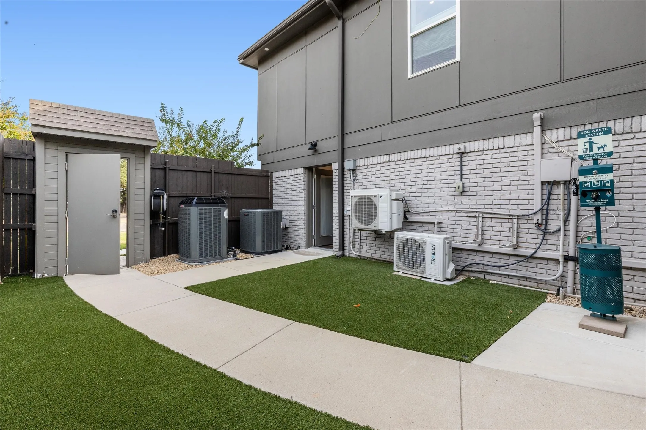 Paved pathway with artificial turf and a dedicated pet waste station