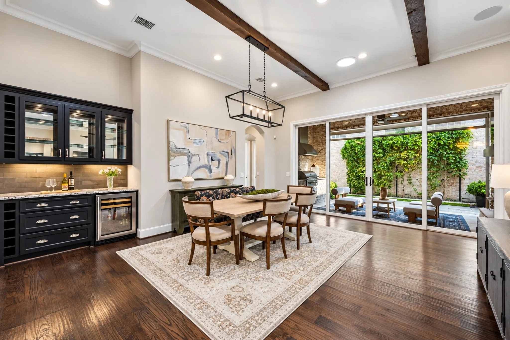 Wood-finish flooring with exposed ceiling beams and recessed lighting
