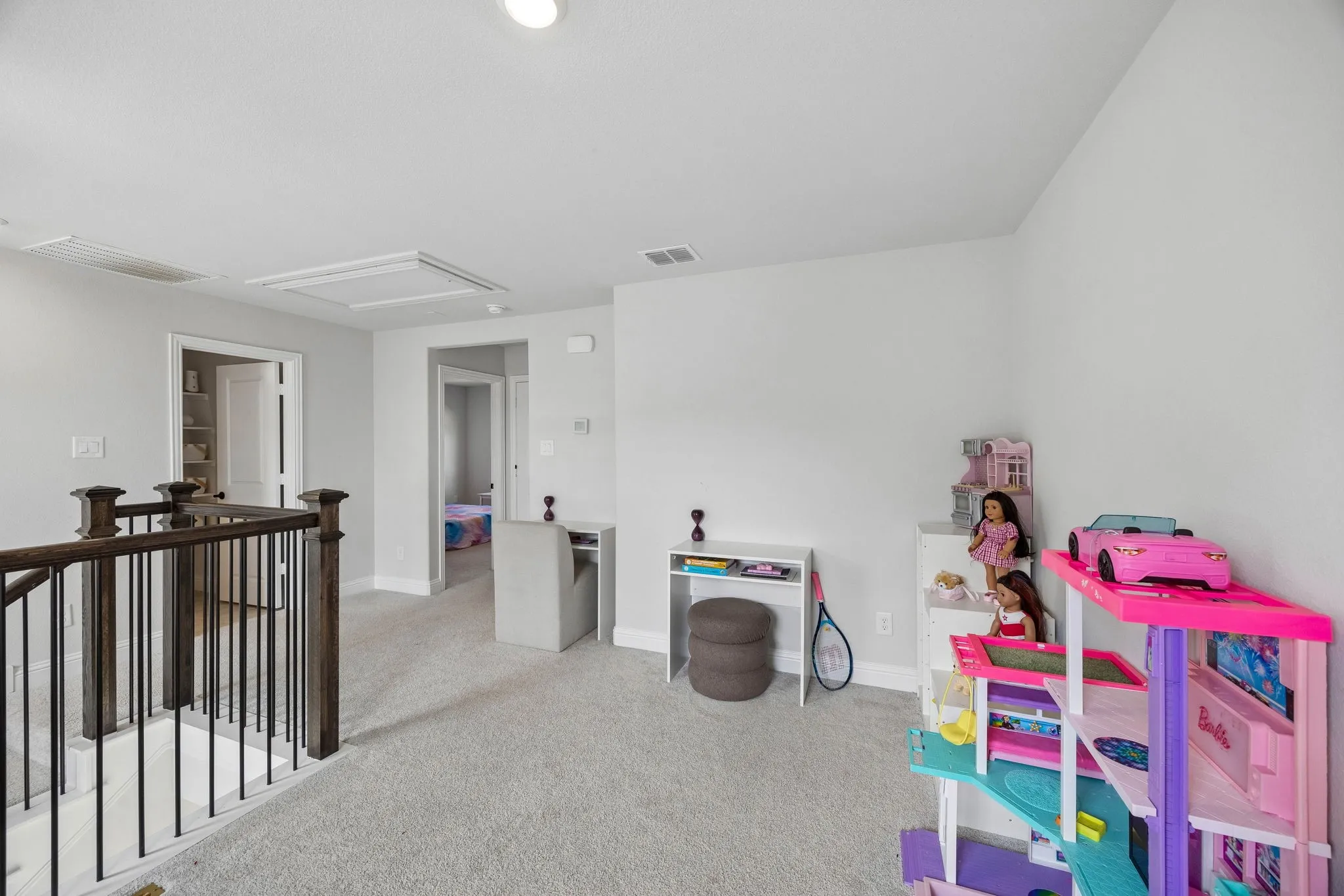 Carpeted loft area with recessed lighting, dark wood and metal railing, and white trim