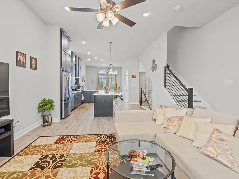 Open-concept living area with wood-finish flooring, a modern ceiling fan, and recessed lighting