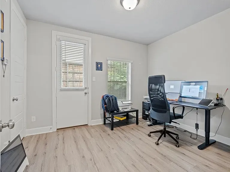 Wood-finish flooring, white walls, white trim, recessed light fixture, and a window with blinds