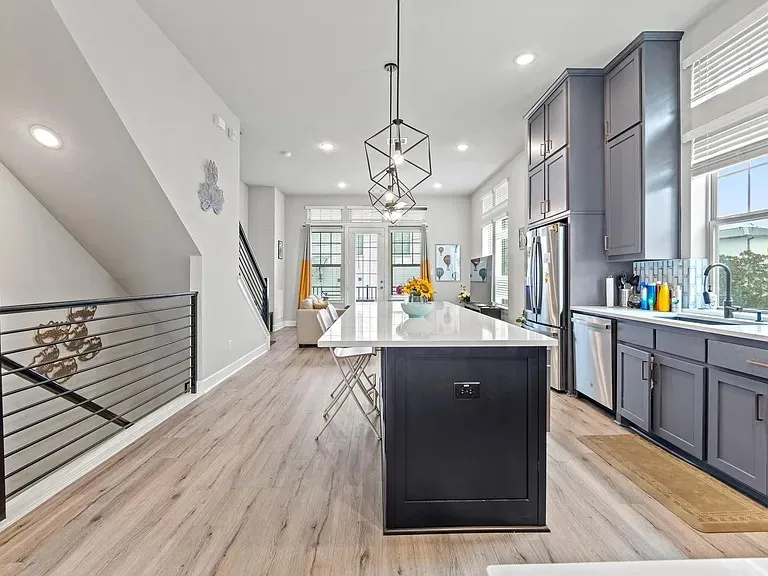 Open-concept kitchen featuring an island, stainless steel appliances, modern cabinetry, and wood-finish flooring