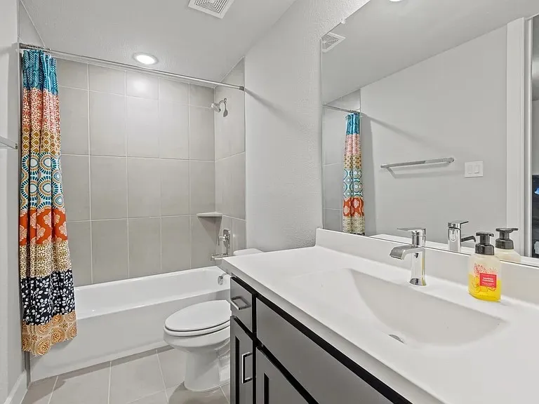 Integrated vanity with a single basin, a chrome faucet, and dark wood-finish cabinetry