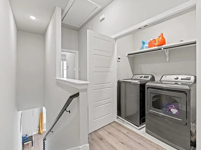 Dedicated laundry area with built-in shelving, wood-finish flooring, and recessed lighting