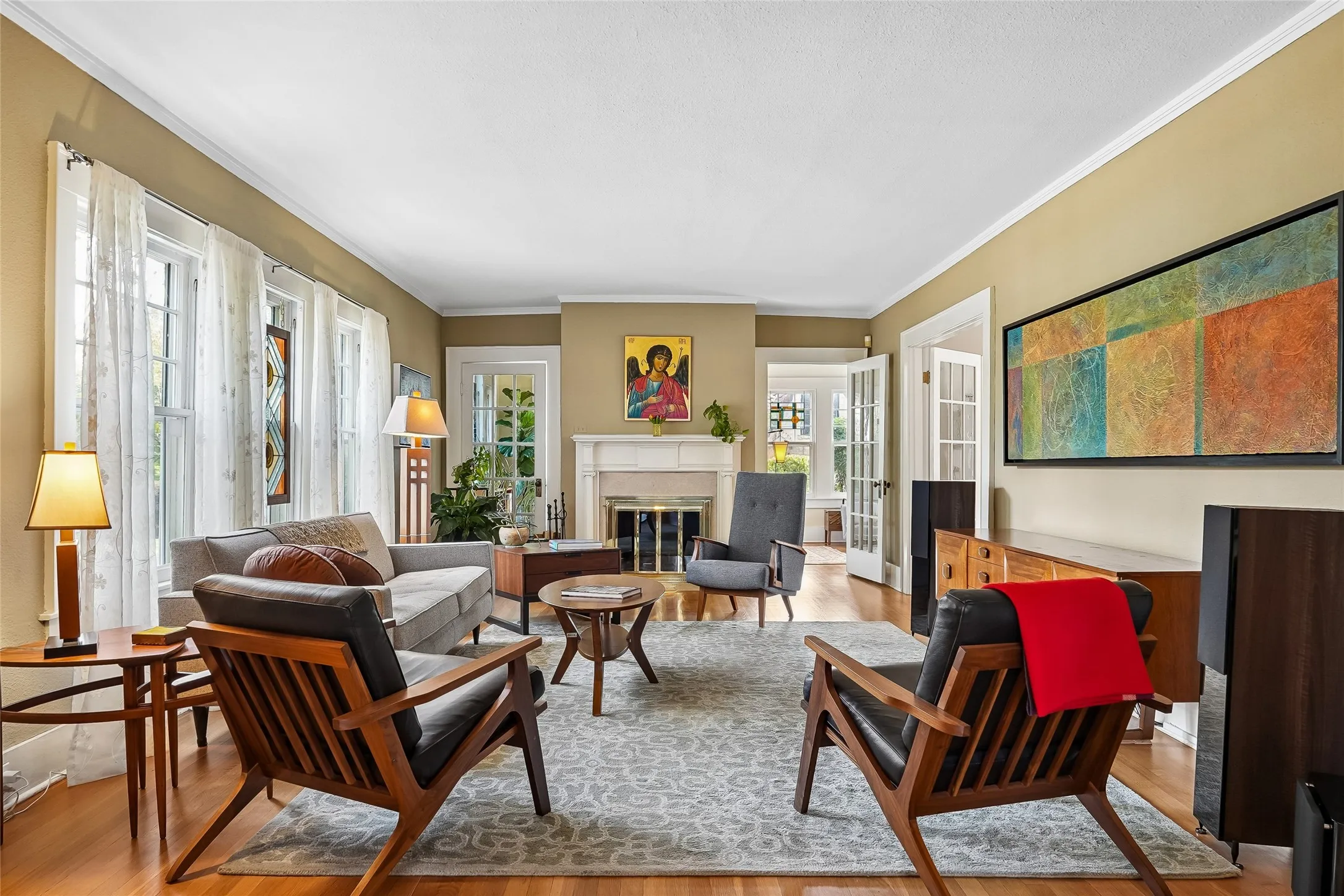 Hardwood flooring, crown molding, double French doors, multiple windows, and a built-in fireplace