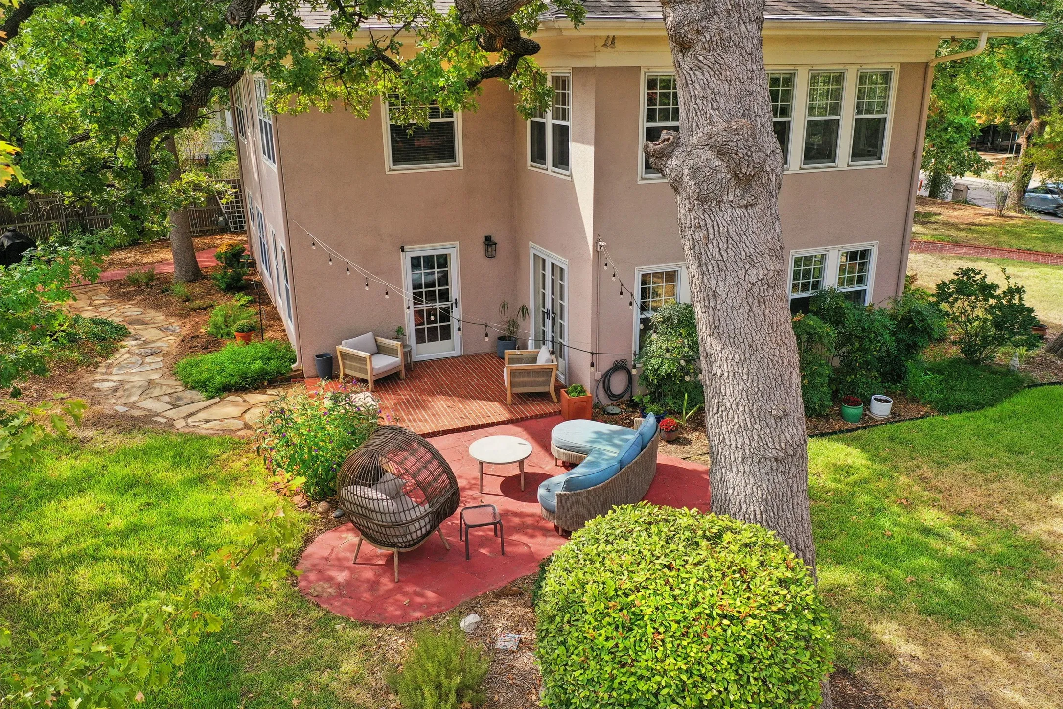 Stucco exterior with multiple windows, leading to a red-toned patio area