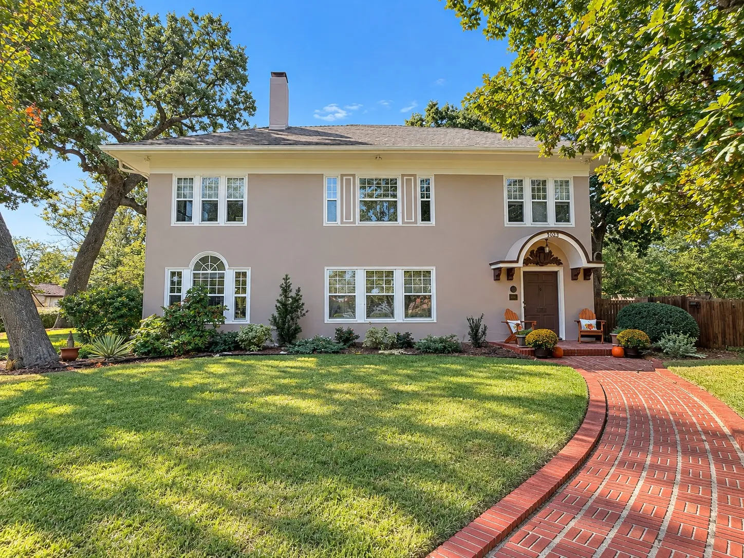 Stucco exterior with a prominent chimney and white trim windows