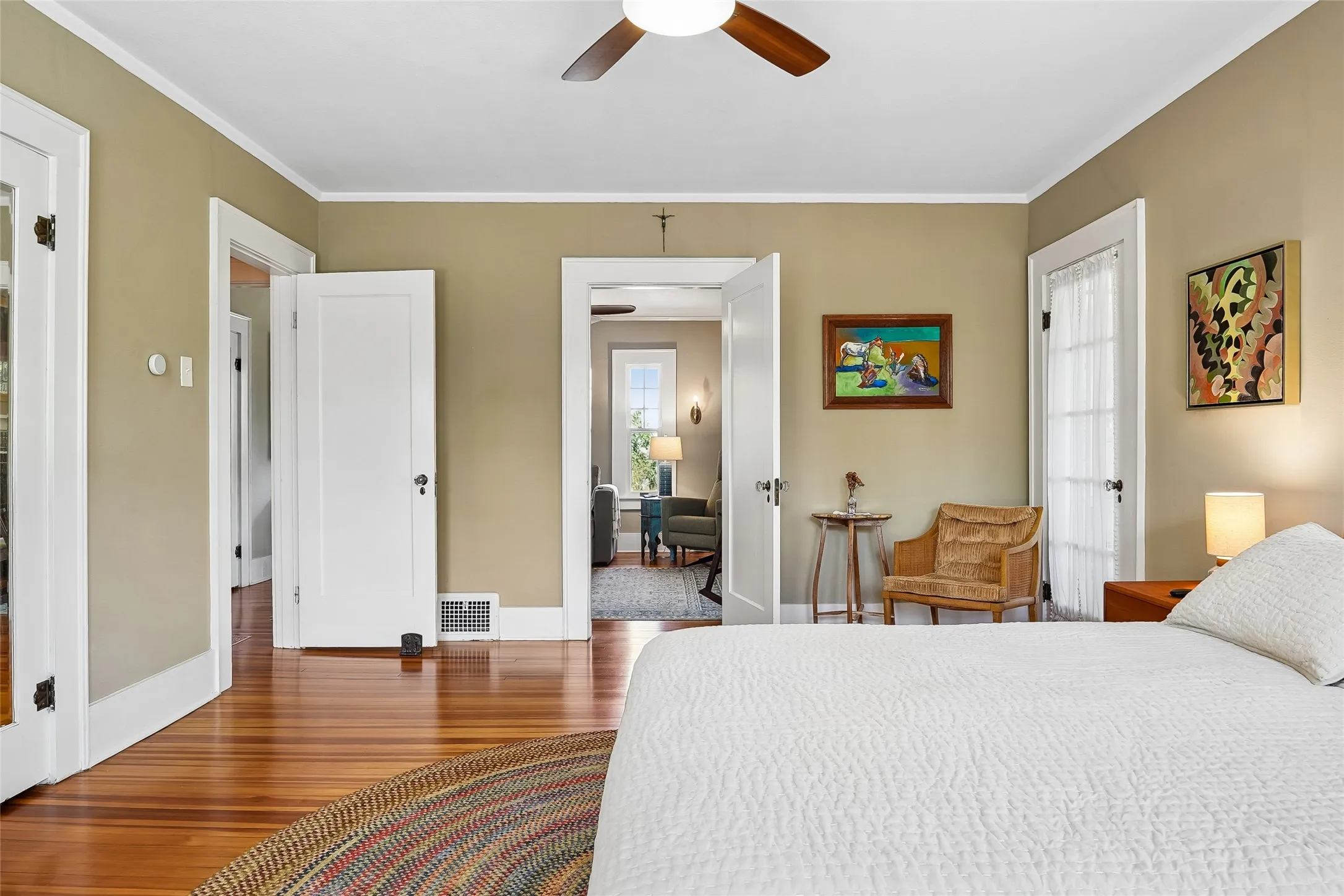 Hardwood flooring throughout, a ceiling fan with integrated lighting, and white trim work