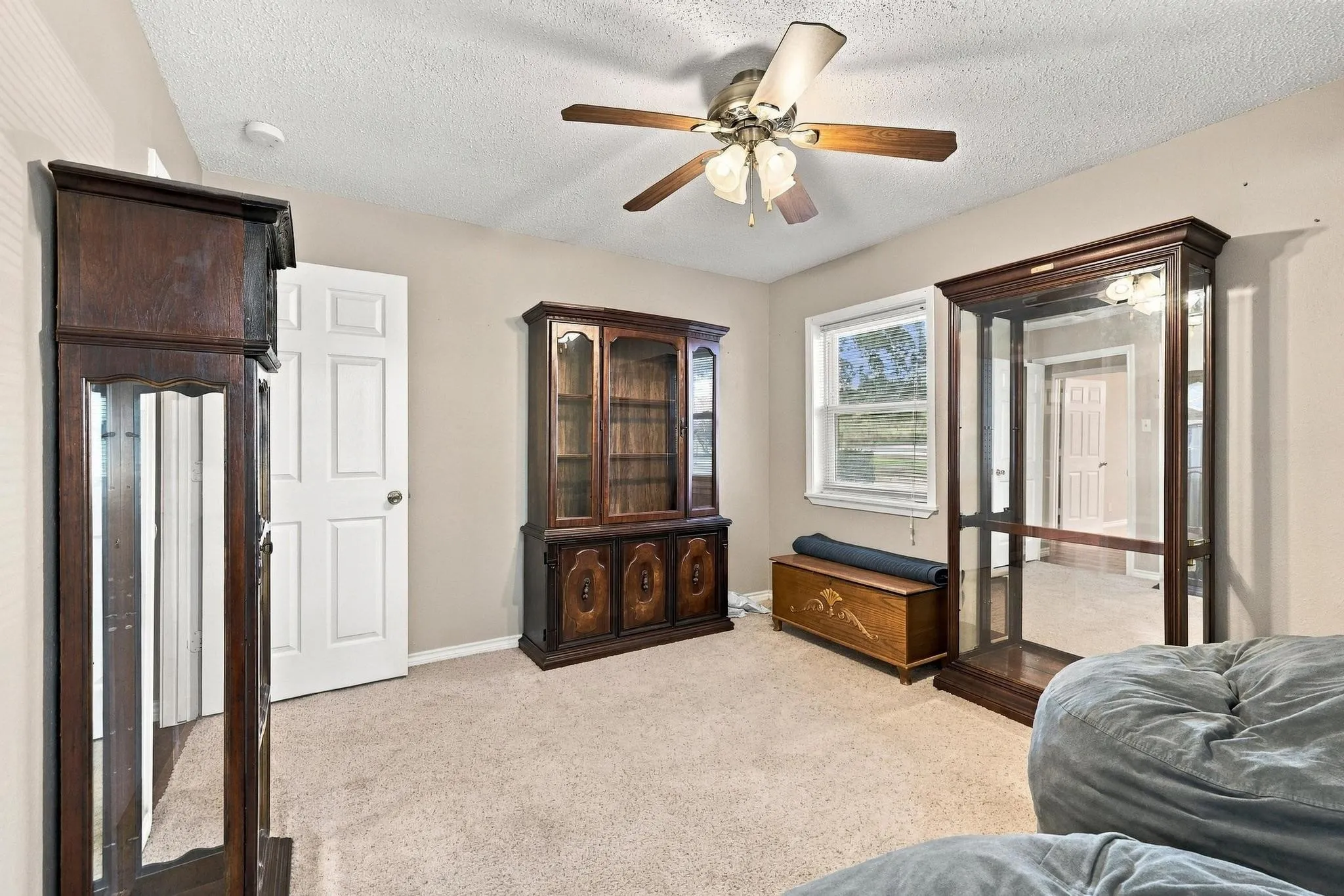 Carpeted flooring, neutral wall paint, ceiling fan