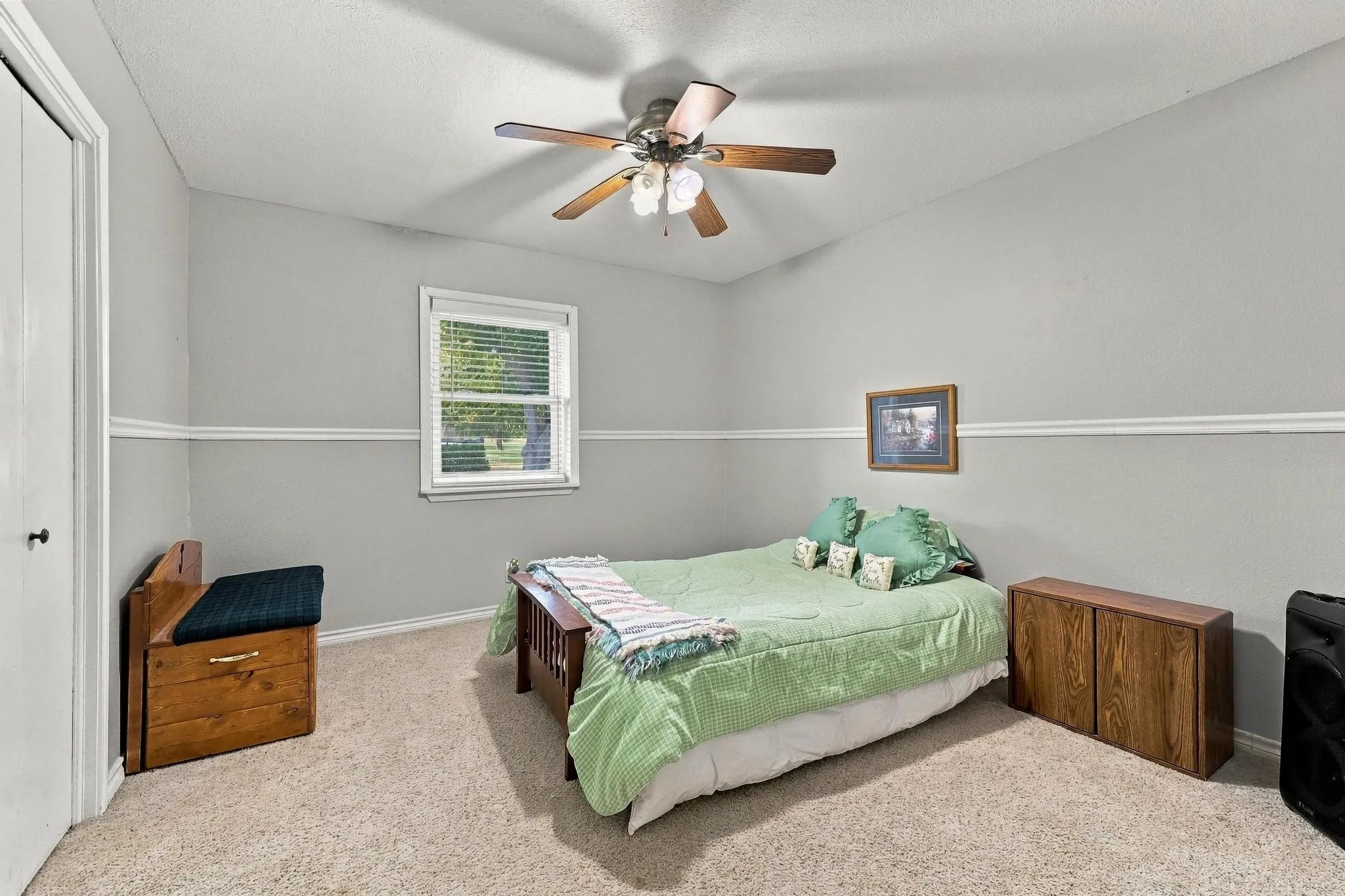 Carpeted flooring with light gray walls, white trim, a single window with blinds, and a ceiling fan with integrated lighting