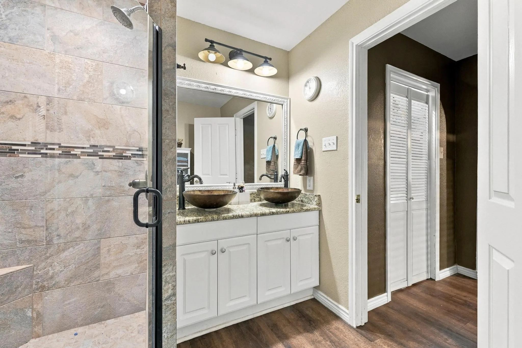 Walk-in shower with tiled walls and decorative accent band