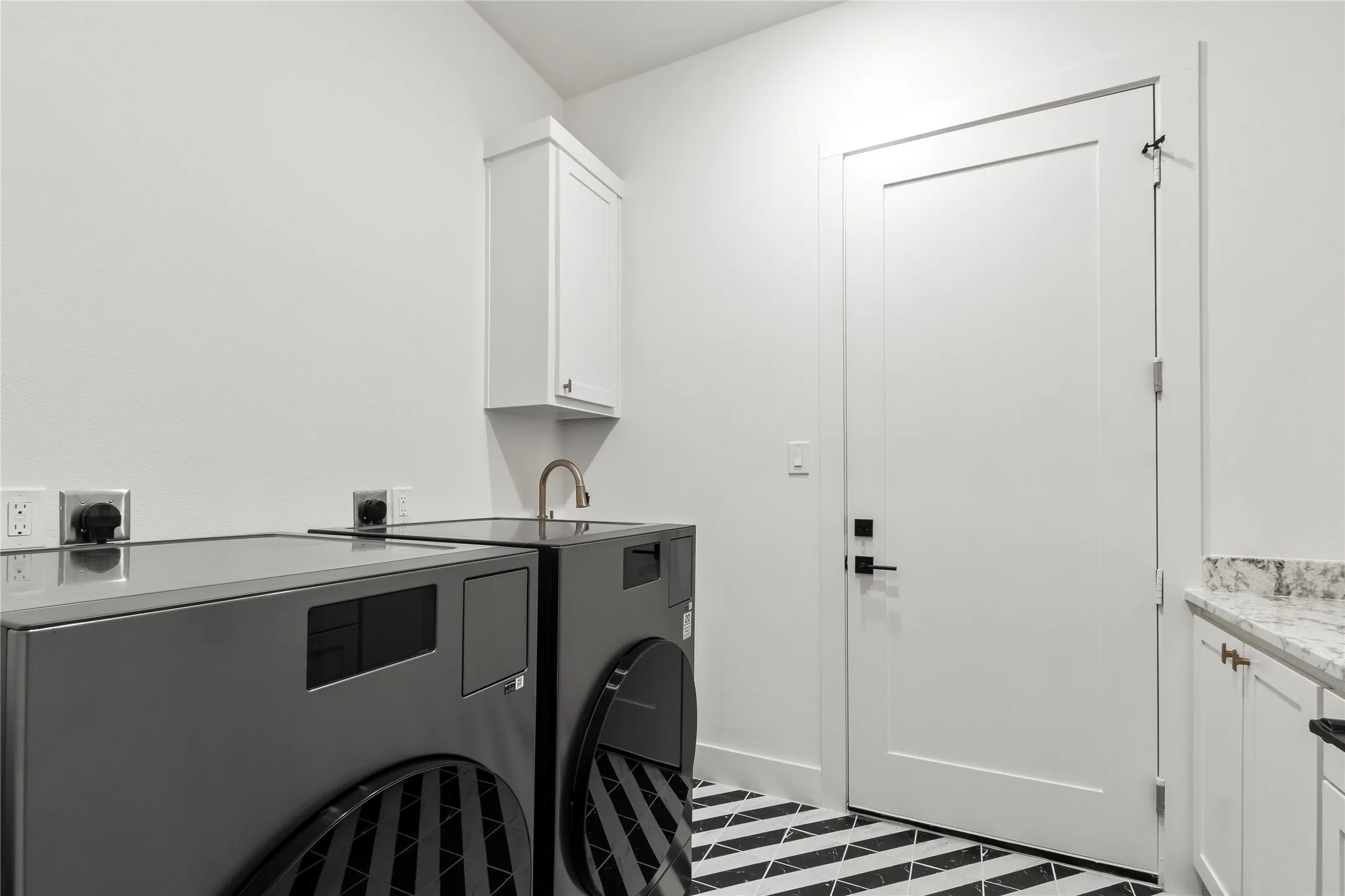 Laundry room downstairs. Home includes two all-in-one washer-dryer combo.