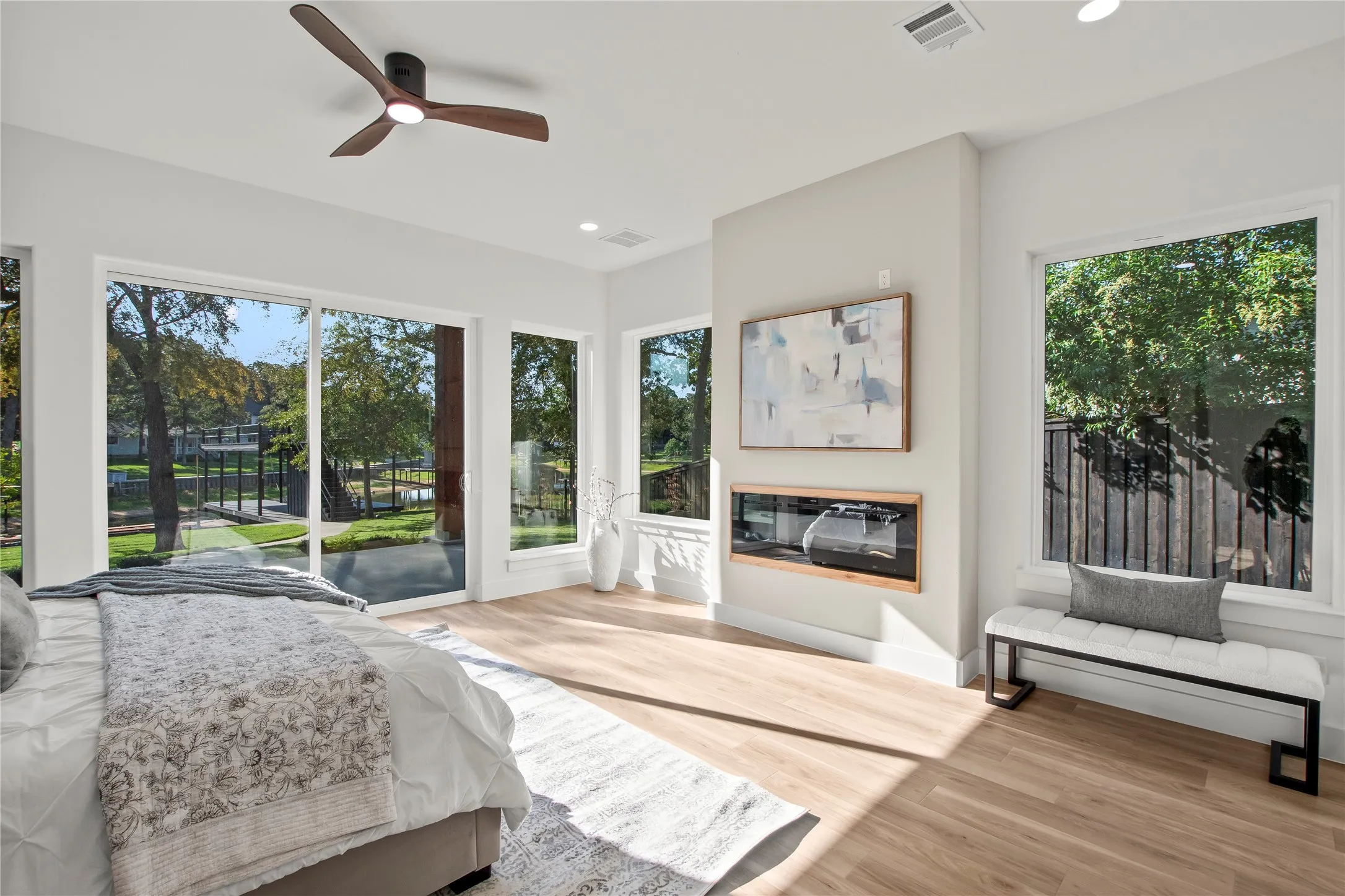 Waterside primary suite (Bedroom #1) with access to patio, and electrical fireplace. Level one