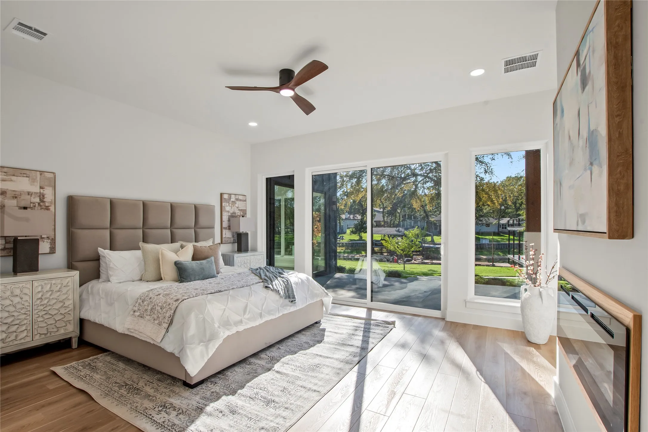 Waterside primary suite (Bedroom #1) with access to patio, and electrical fireplace. Level one
