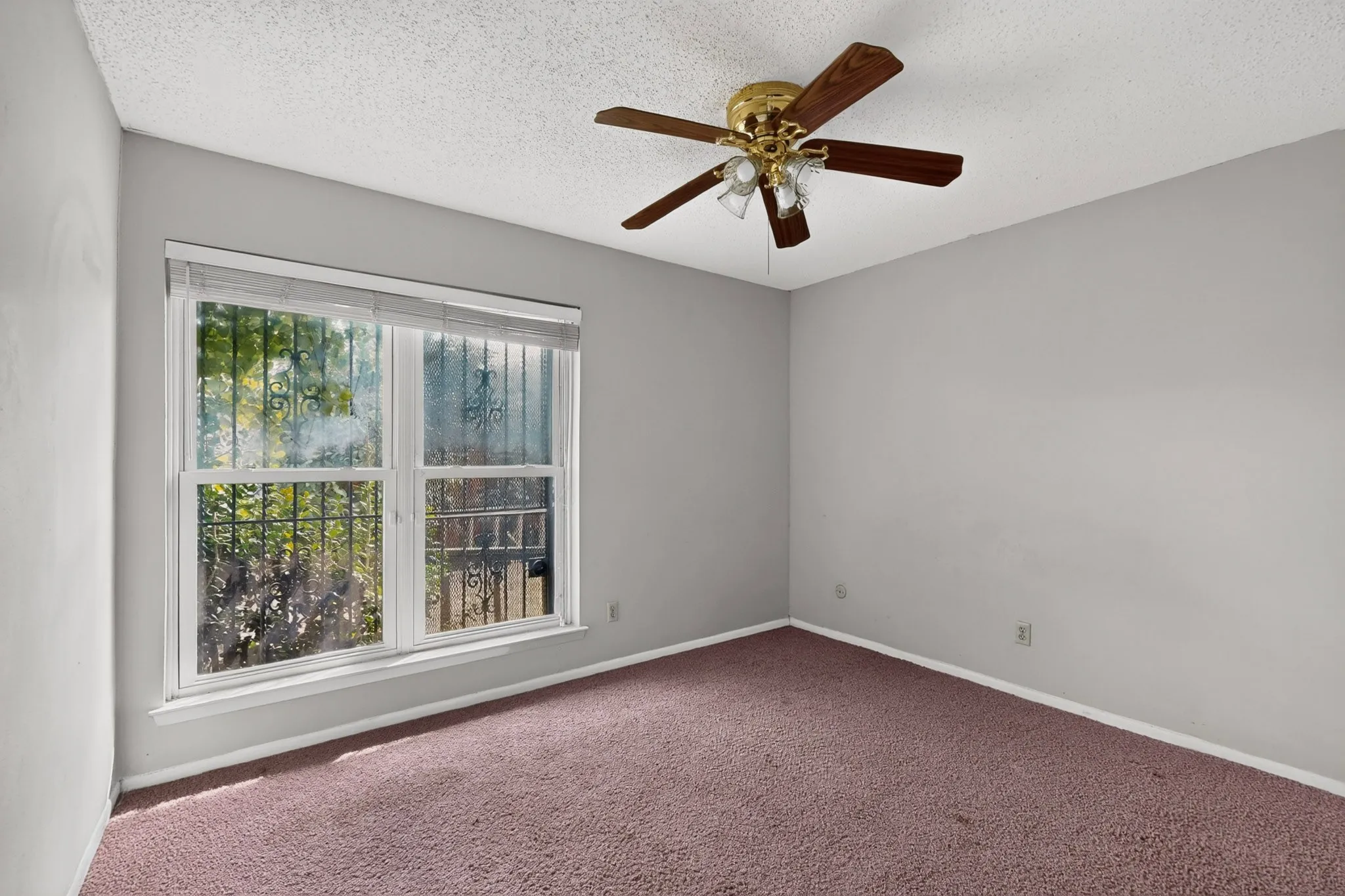 Room featuring a ceiling fan with integrated lighting, a double window, and carpet flooring