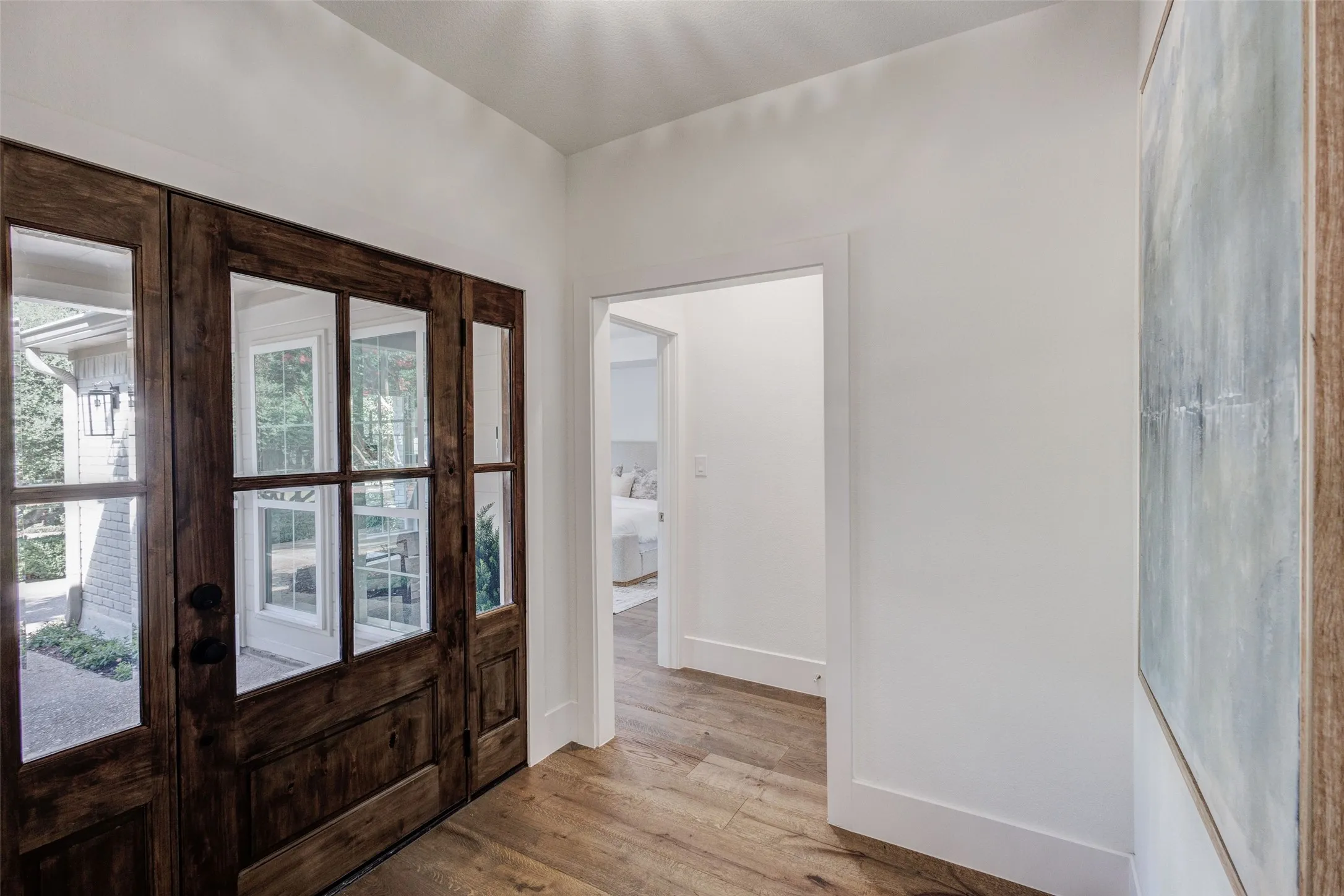 Rich wood-finish front entry double doors with glass panels and a sidelight