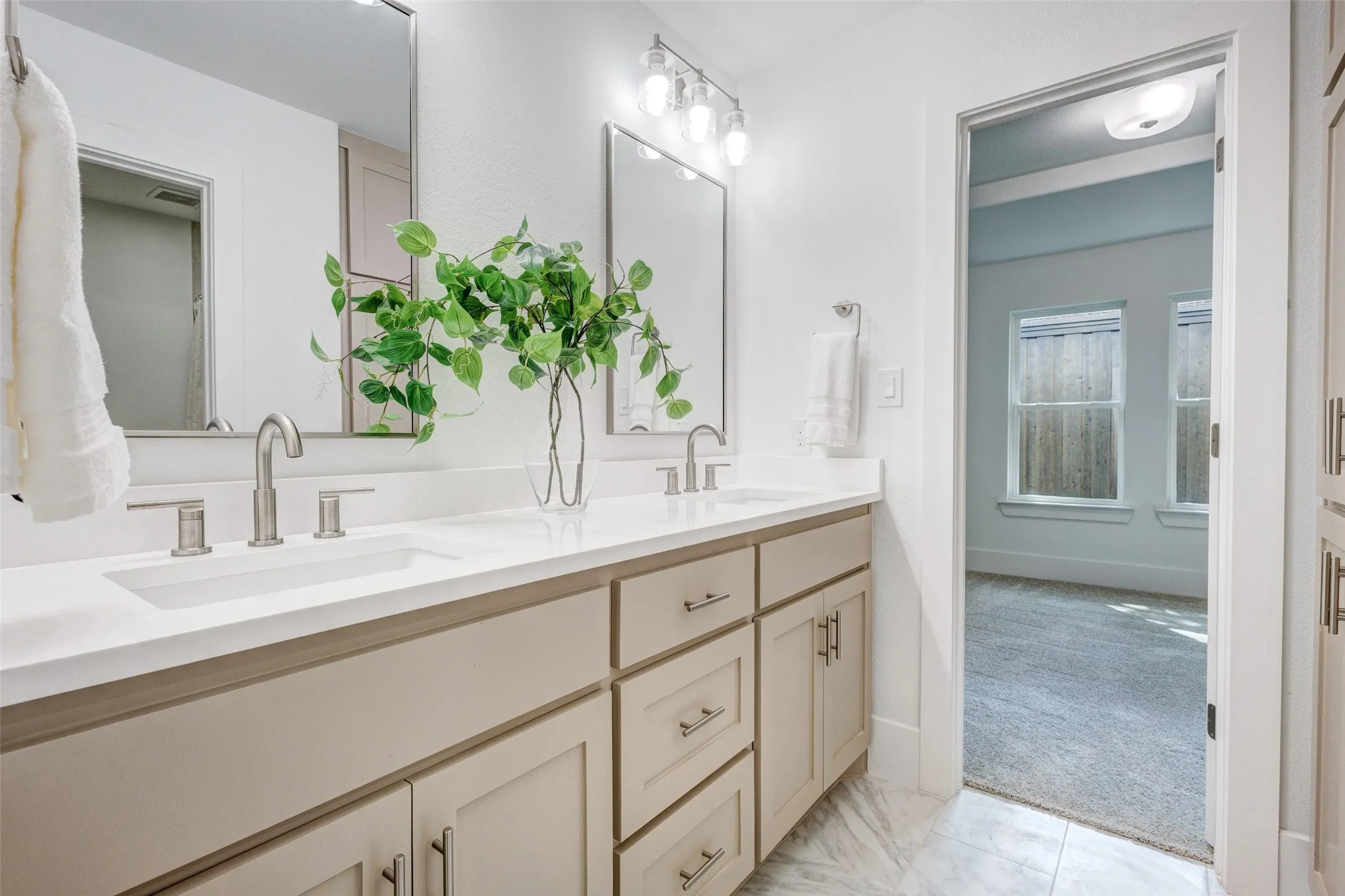 Dual vanity with undermount sinks, brushed nickel faucets, and a white countertop