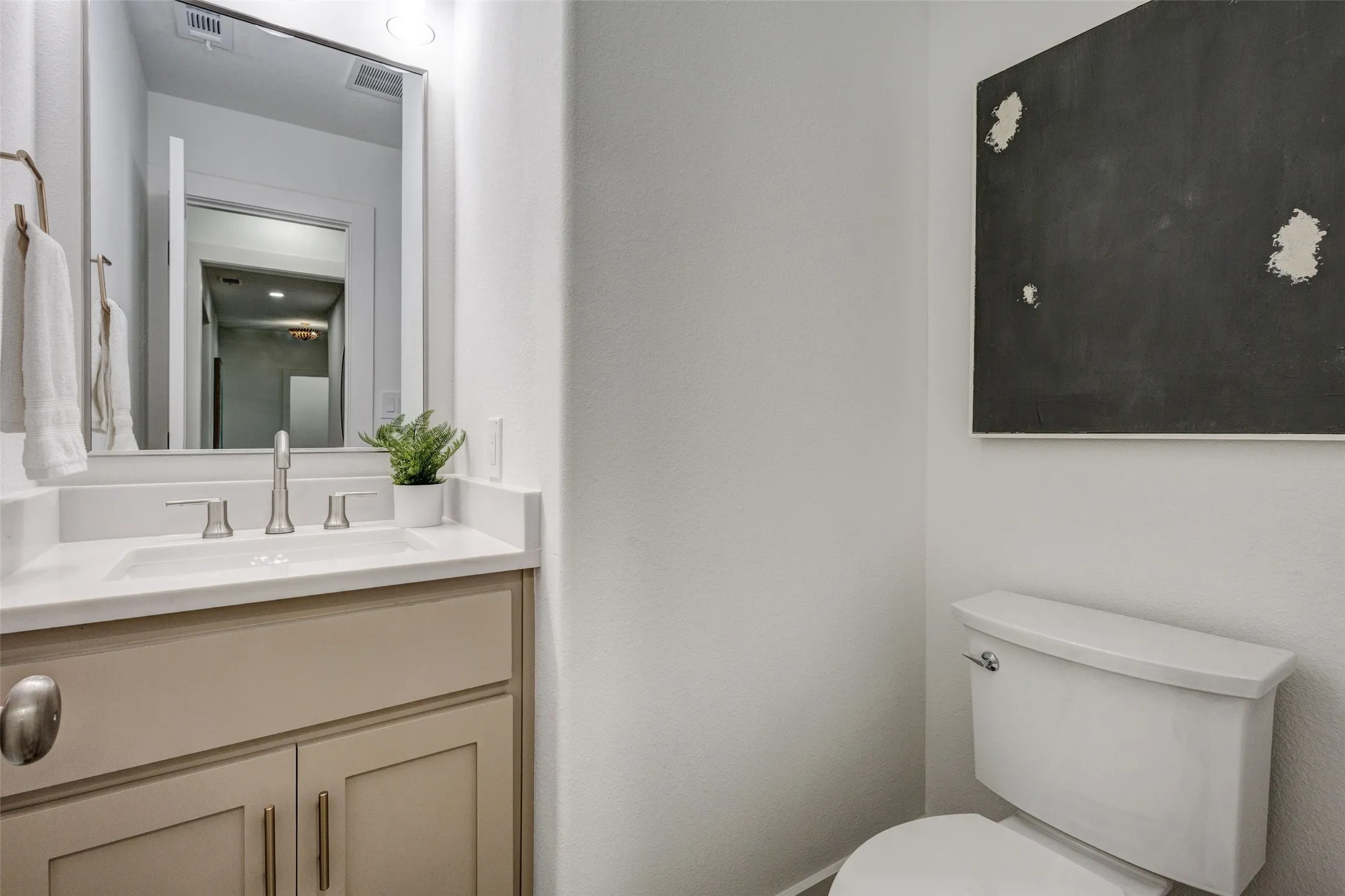 Vanity with an integrated rectangular sink, light-colored countertop, and brushed nickel faucet
