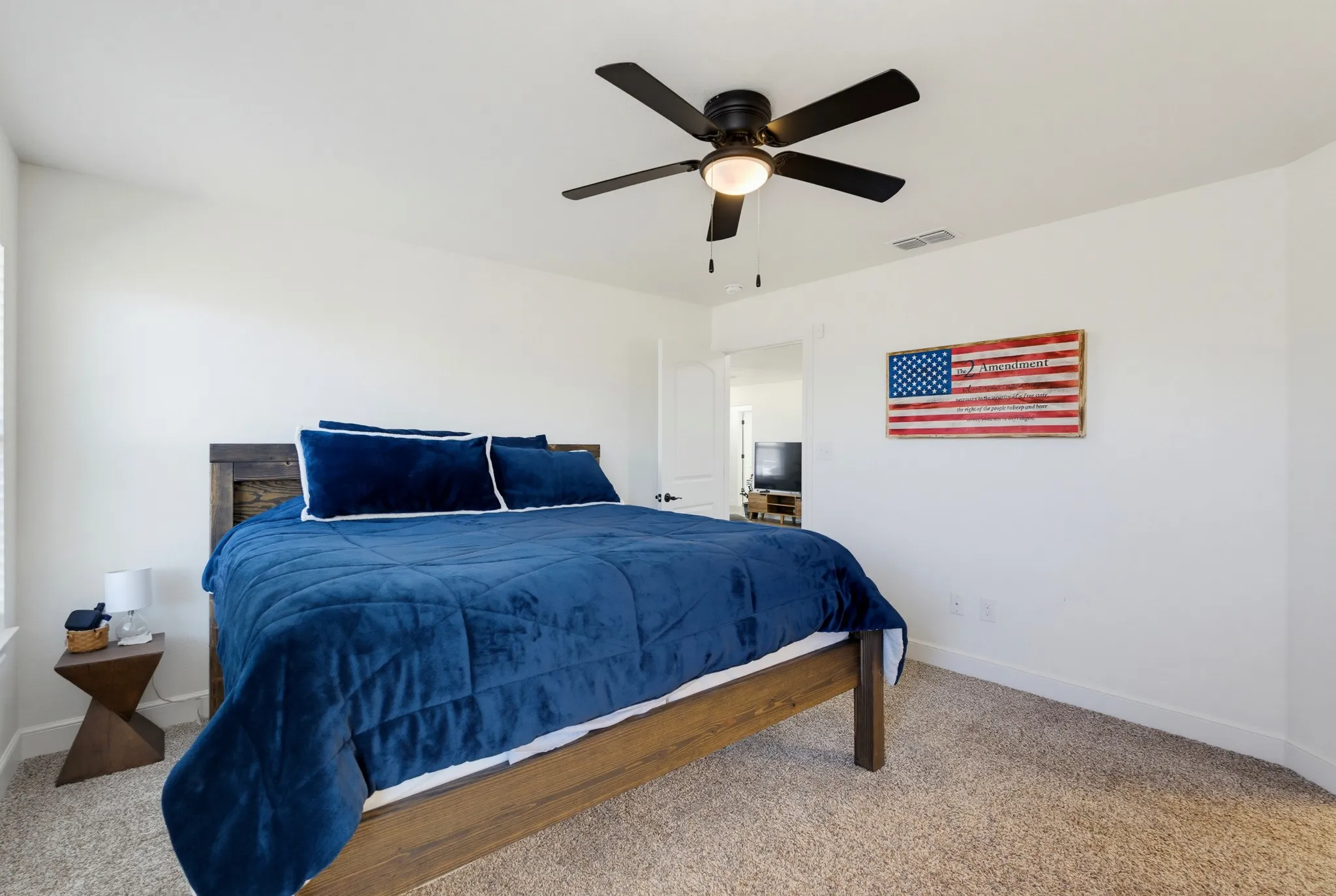 Carpeted flooring, ceiling fan with integrated lighting, and a neutral color palette