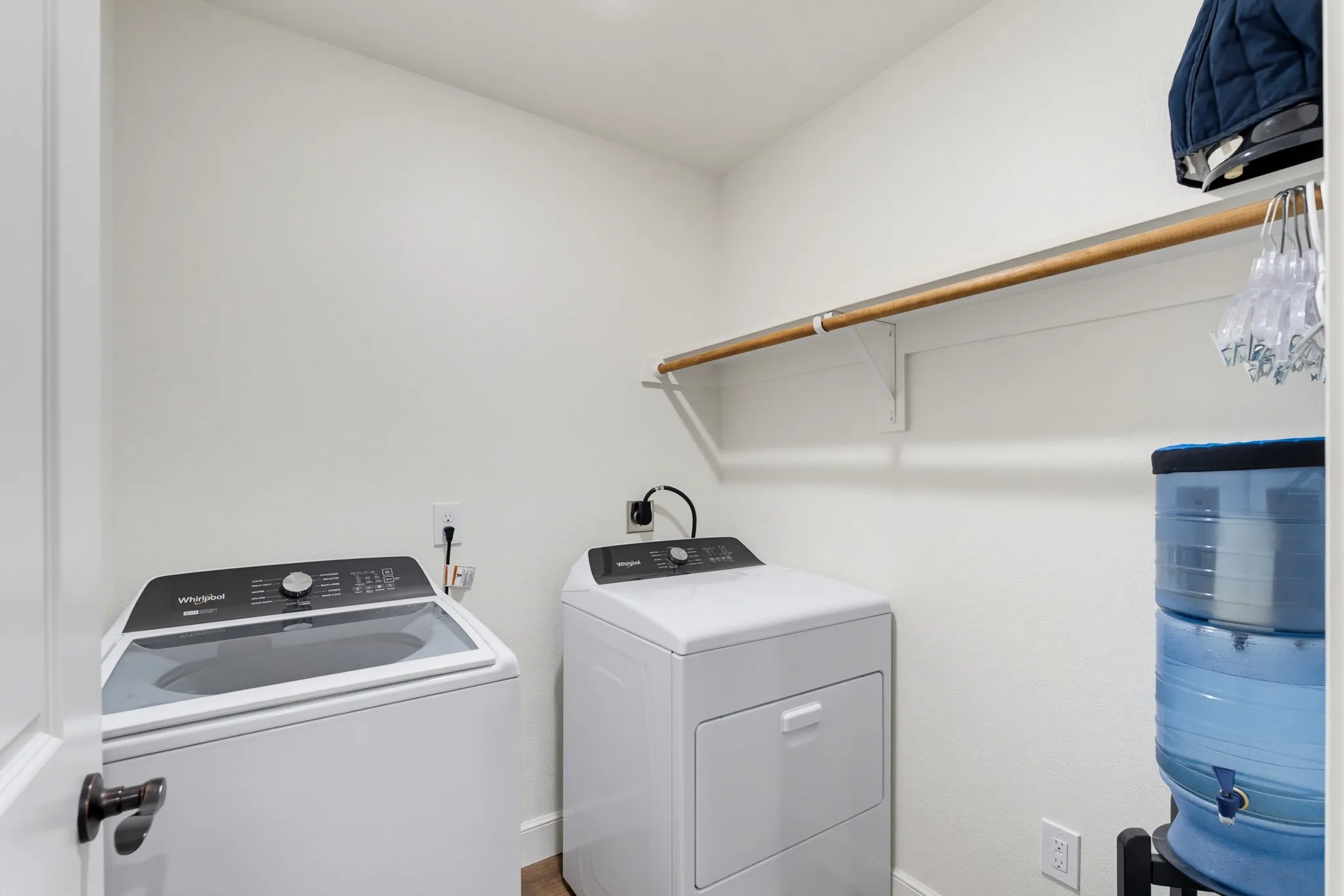 Laundry space featuring a clothes rod with shelving, and wood-finish flooring