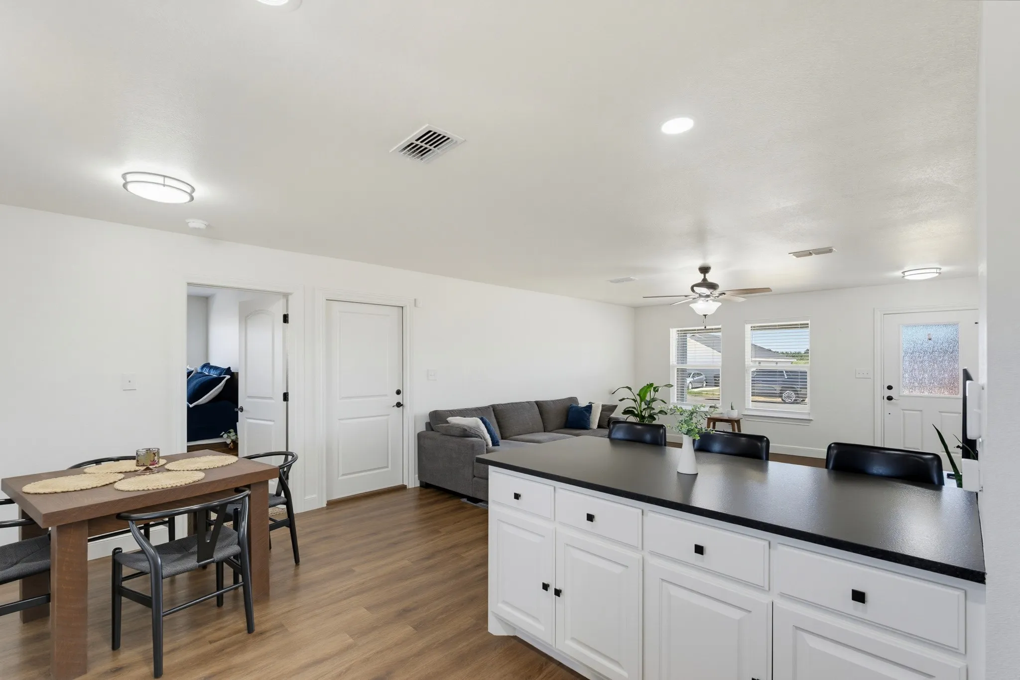 White shaker cabinetry with dark hardware and a contrasting countertop