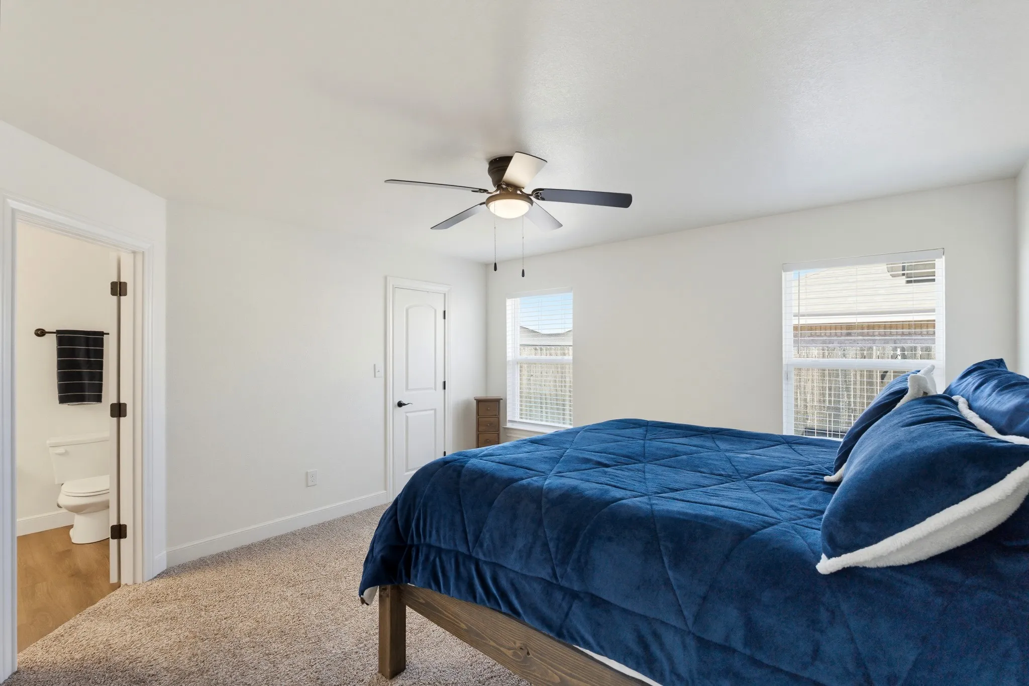 Recessed lighting, wood-finish flooring, white paneled door, ceiling fan, and dual windows