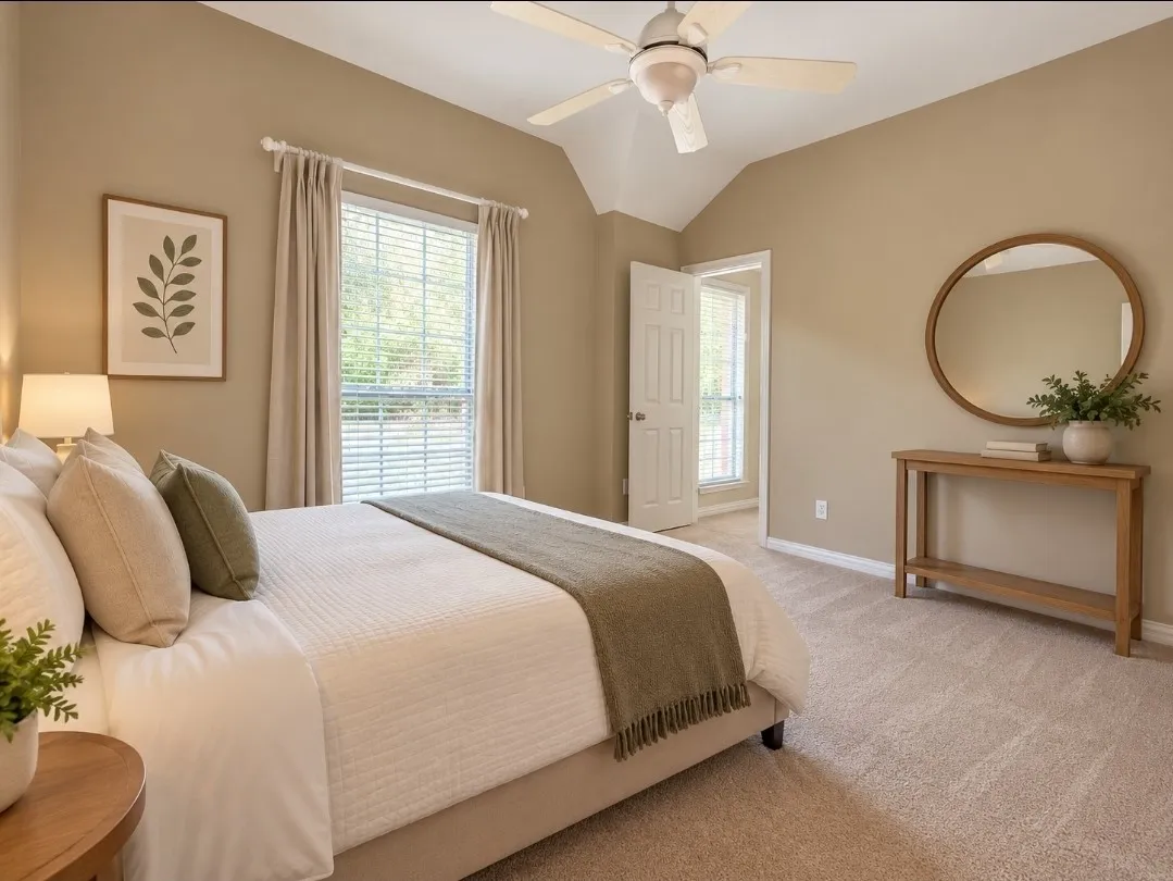 Vaulted ceiling with a ceiling fan, window with blinds and drapes, wall-to-wall carpeting, and a wooden console table