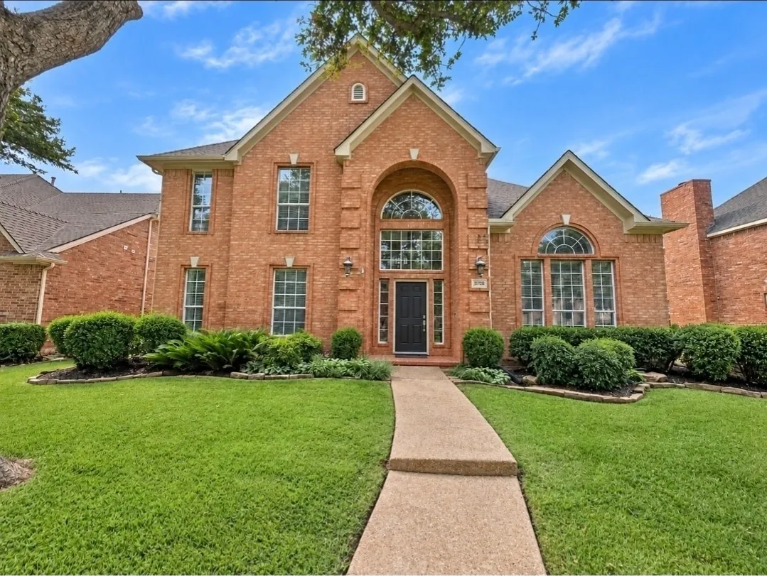 Brick exterior with multiple gables, arched windows, and a prominent chimney feature